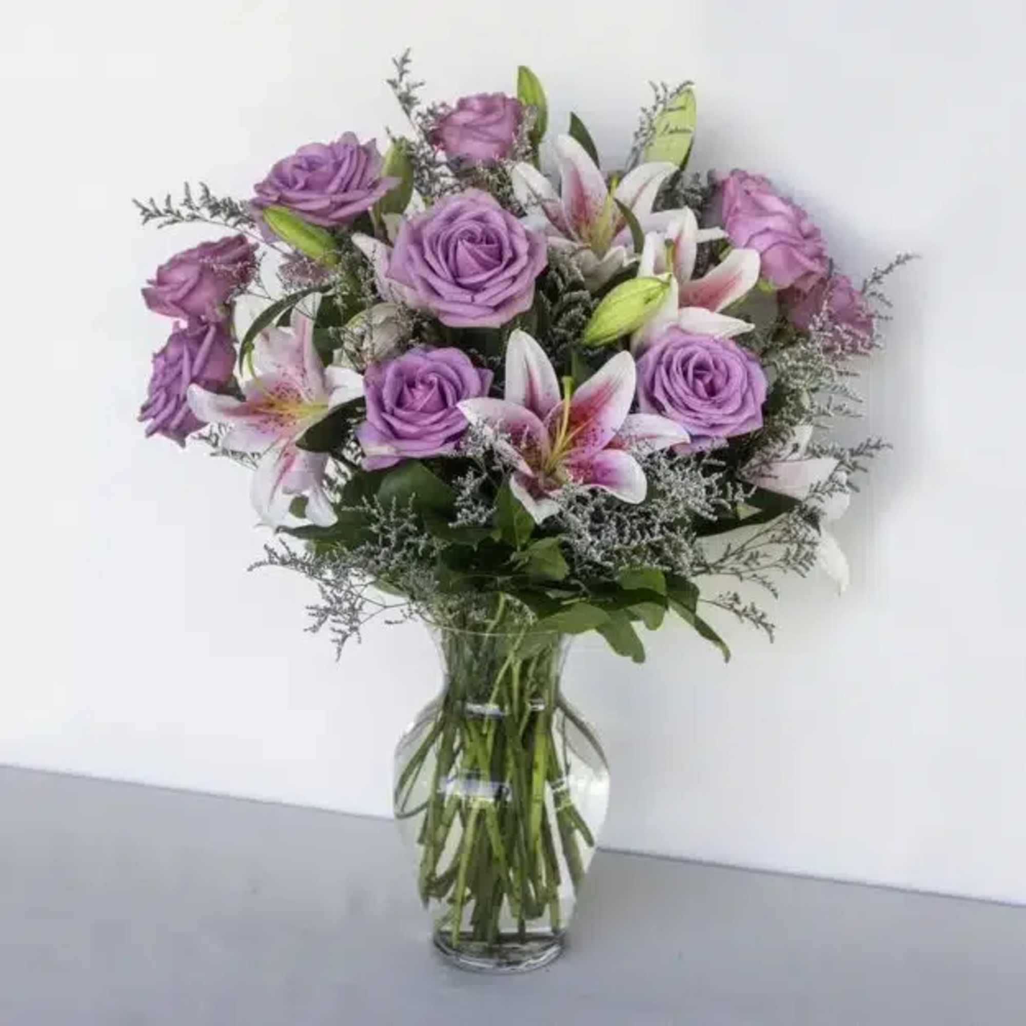 A gorgeous bouquet consisting of a dozen purple roses paired with majestic