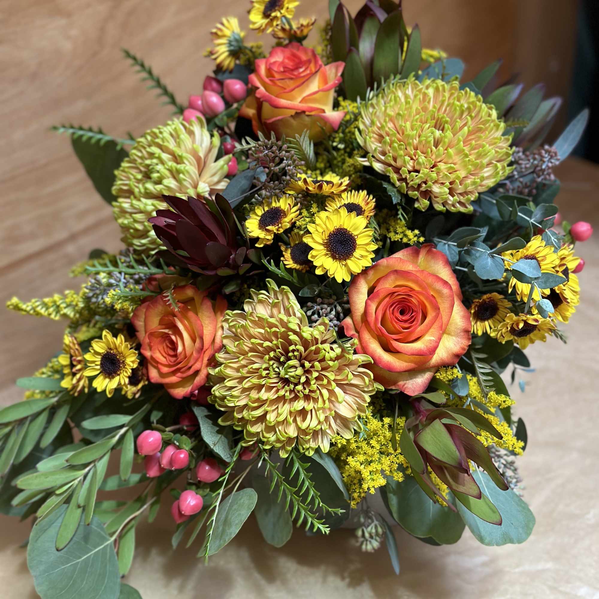 Bouquet of orange roses and yellow chrysanthemums with small sunflowers