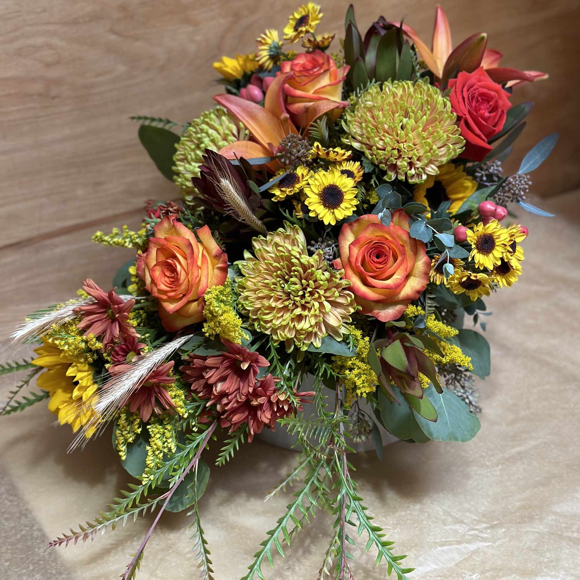 Mixed bouquet with orange roses, green mums, and yellow sunflowers