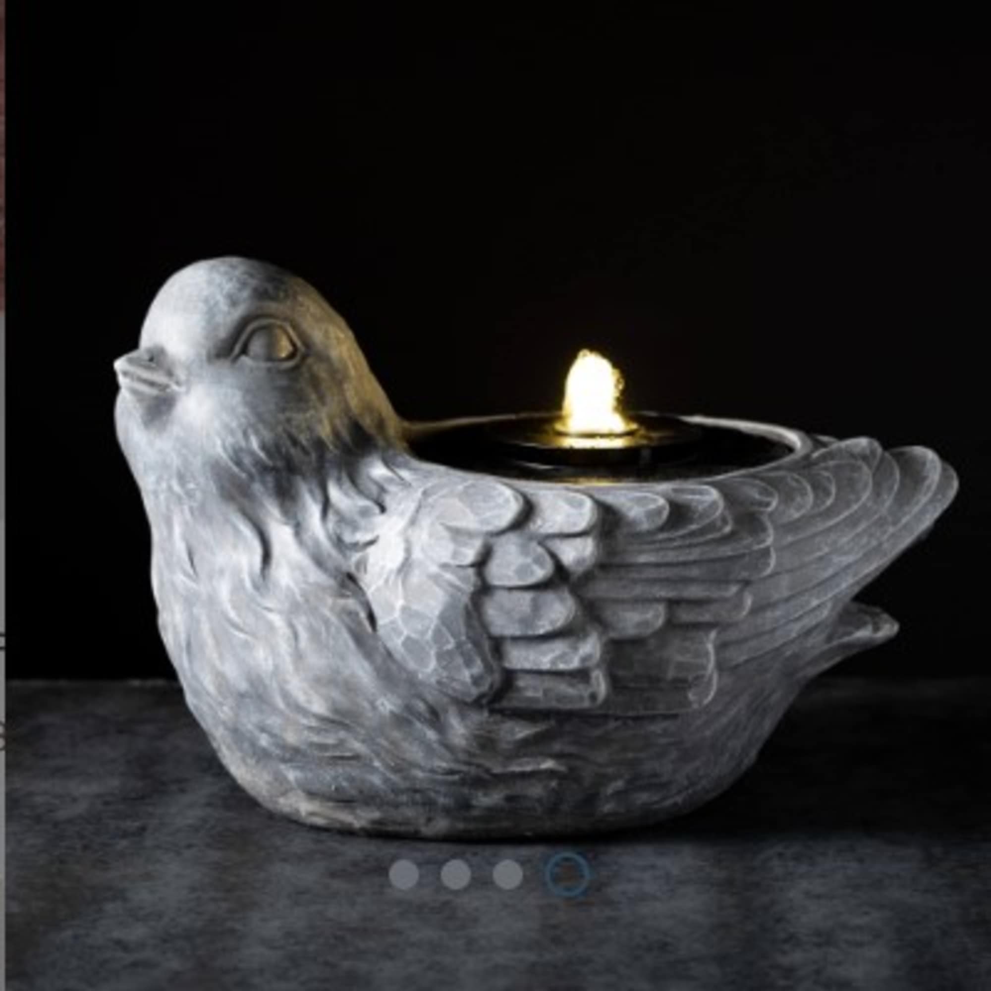 Gray bird-shaped candle holder with a lit flame
