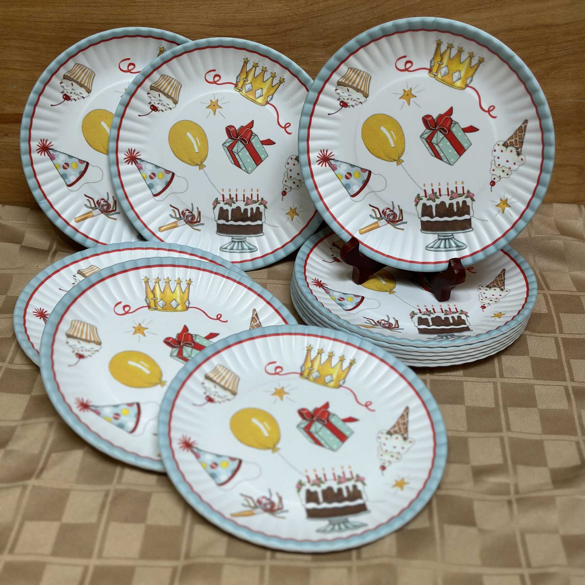 Stack of birthday-themed paper plates with cake and gift illustrations