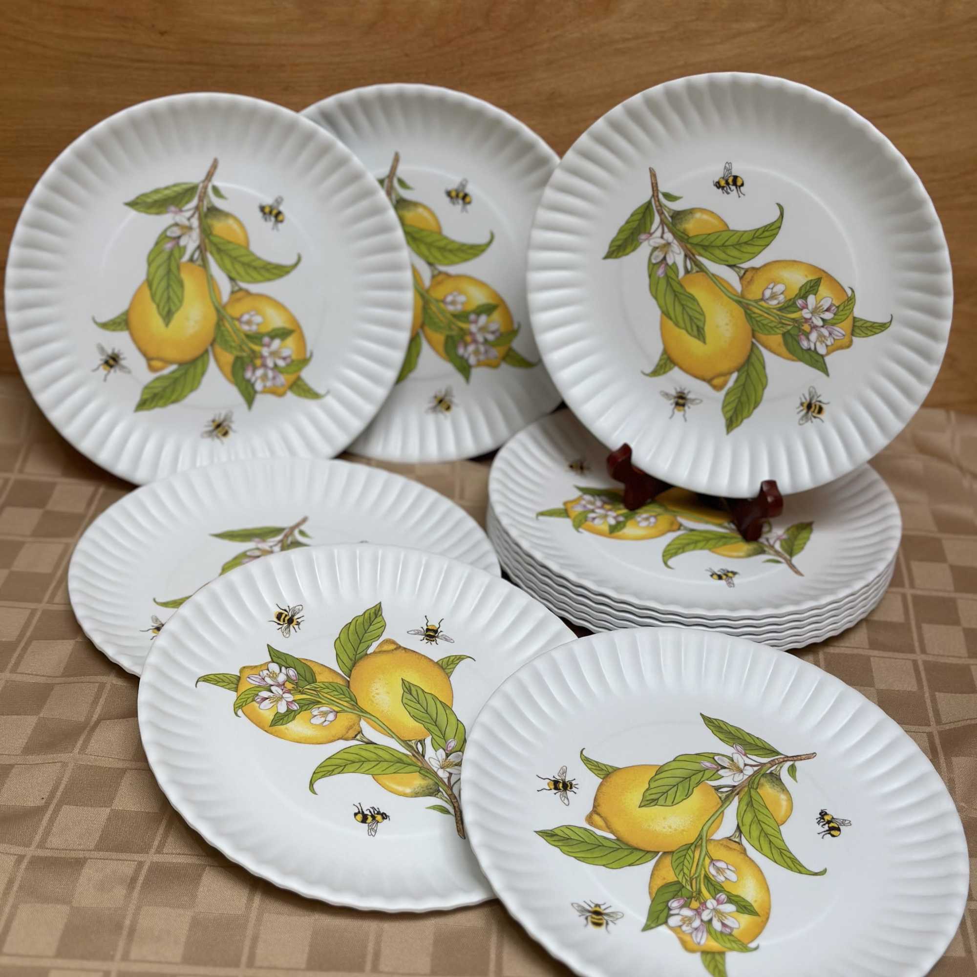 Stack of white plates with lemon and bee designs