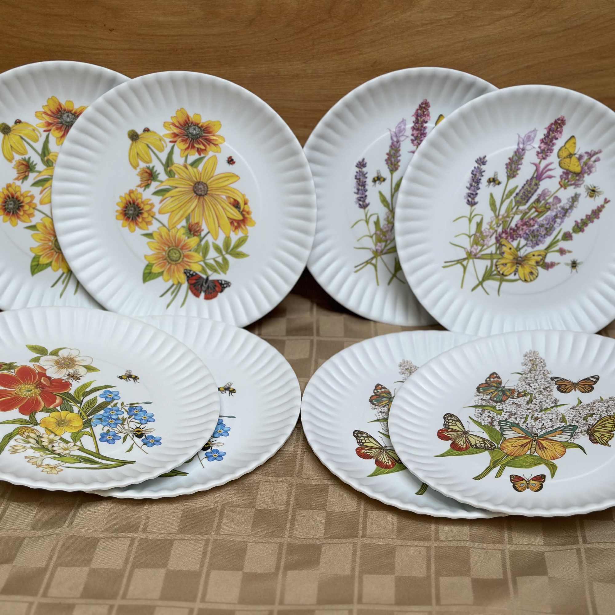 Set of white scalloped plates with floral and butterfly prints