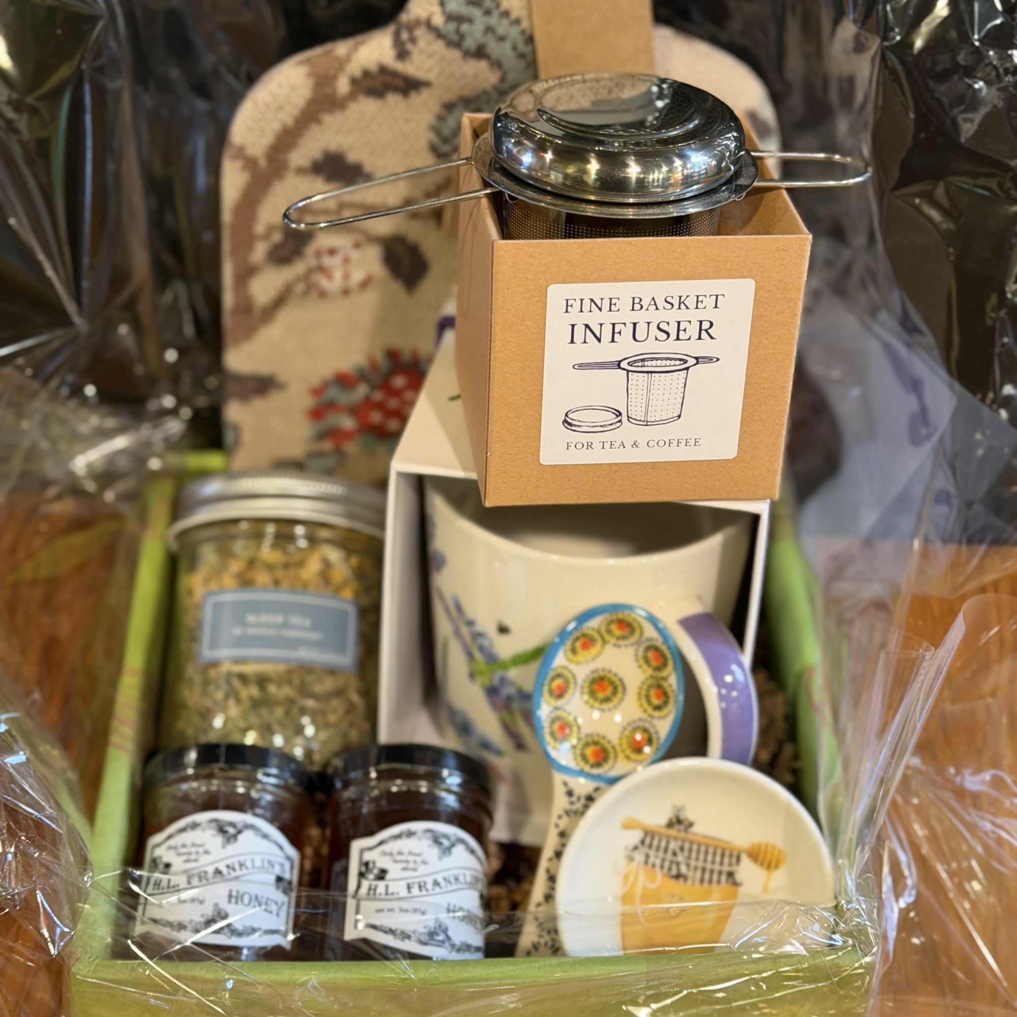 Gift basket with tea infuser, honey jars, and a mug