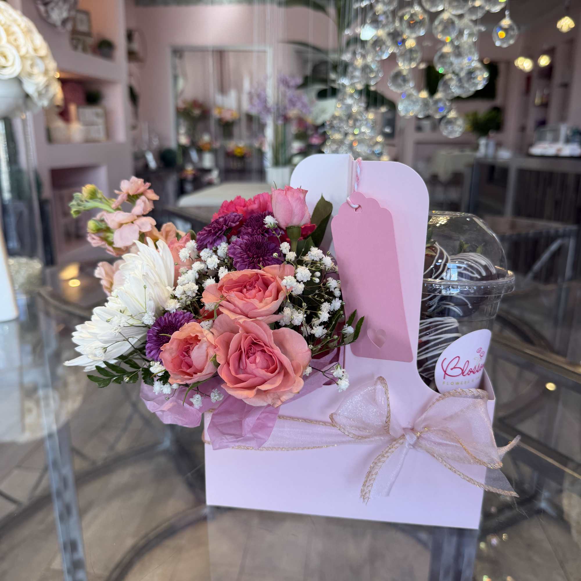 Pink and purple bouquet in a pastel gift box with a ribbon