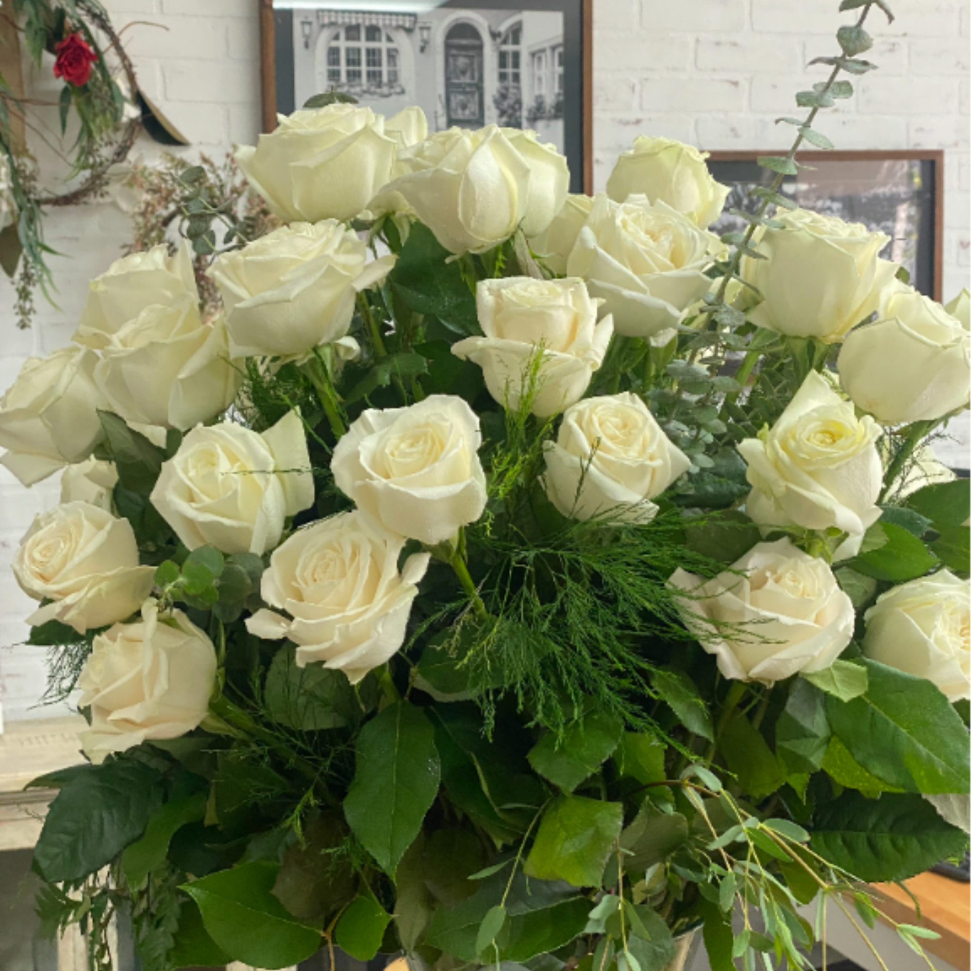 Over 2 dozen creamy white roses with lush green foliage in a, photo 2 of 2