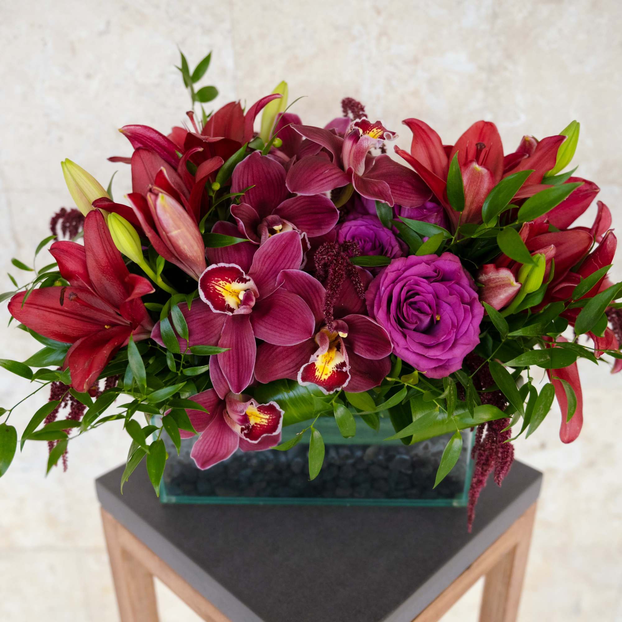 Magenta and red floral arrangement in a rectangular glass vase