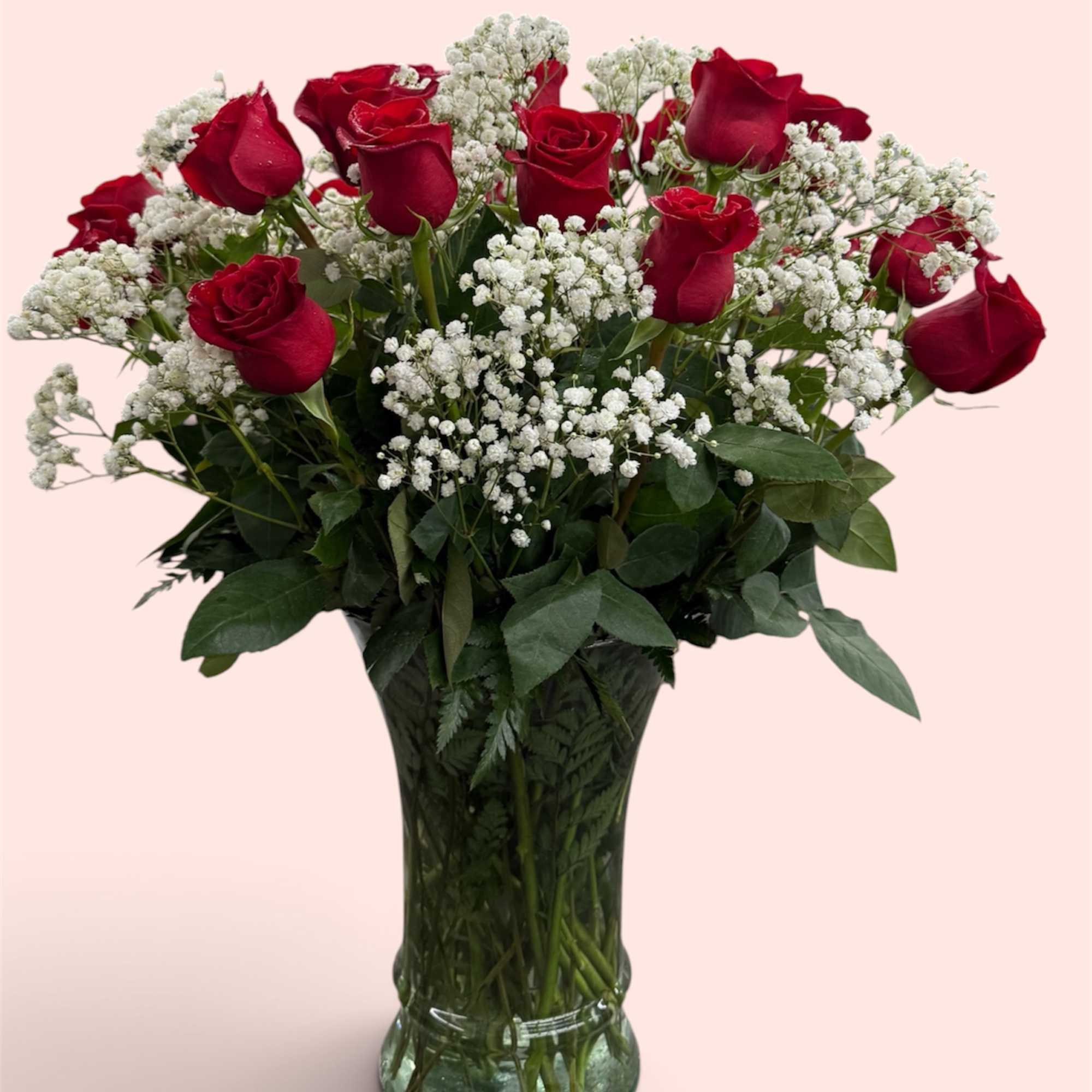 Red roses and white baby's breath in a clear glass vase