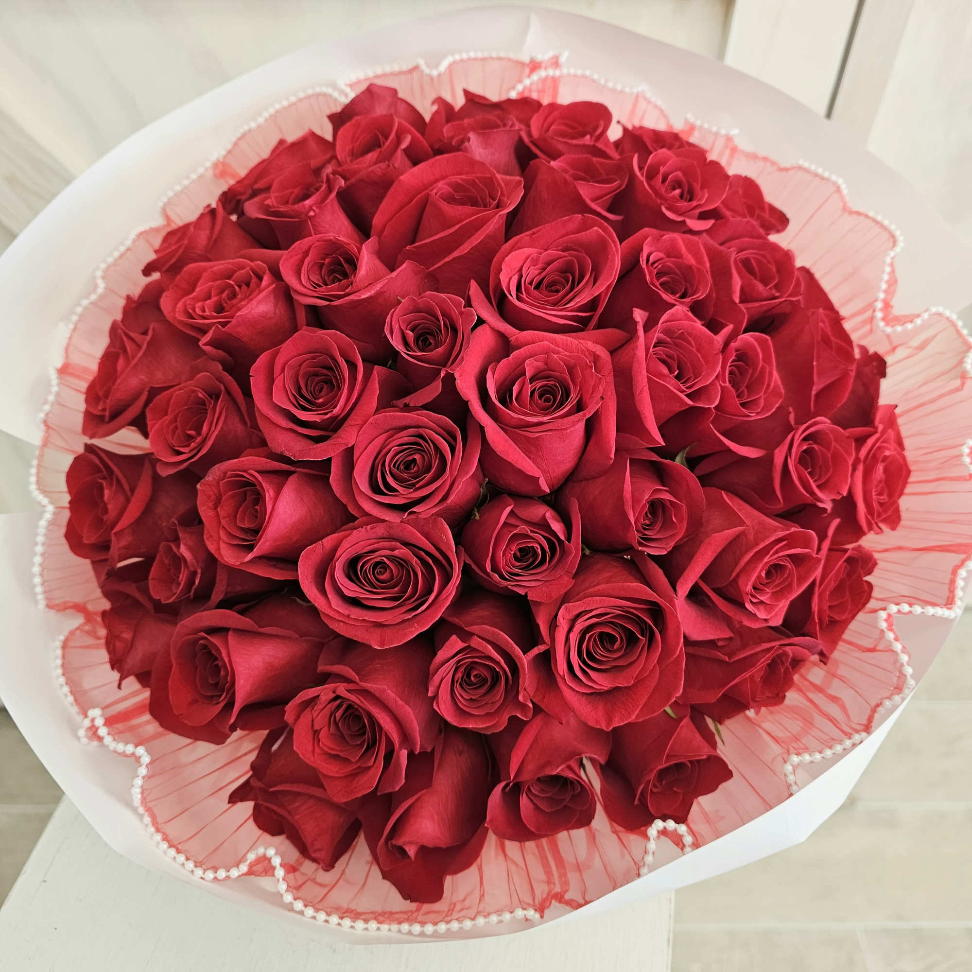 Bouquet of red roses wrapped in pink paper