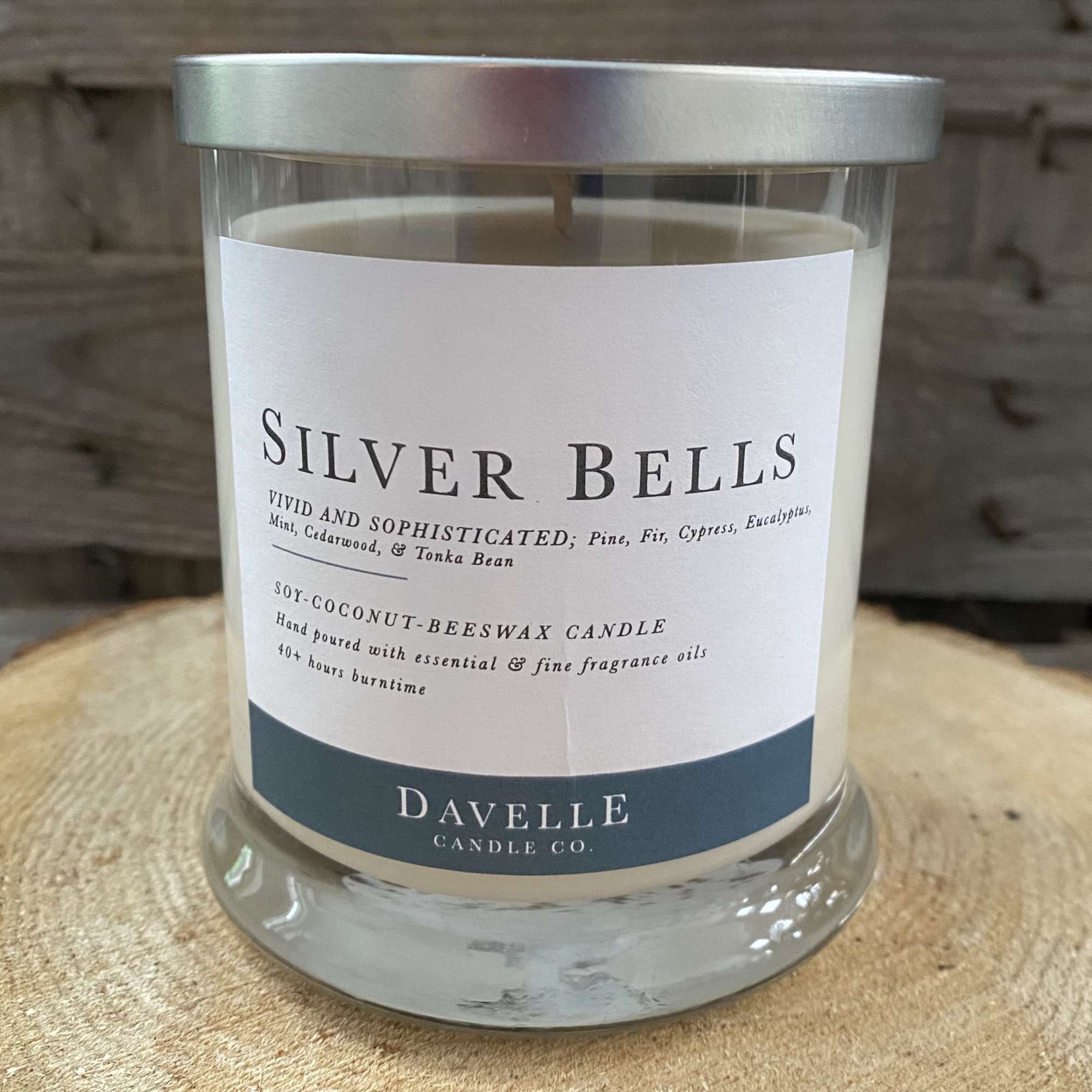 Glass jar candle labeled Silver Bells with a silver lid