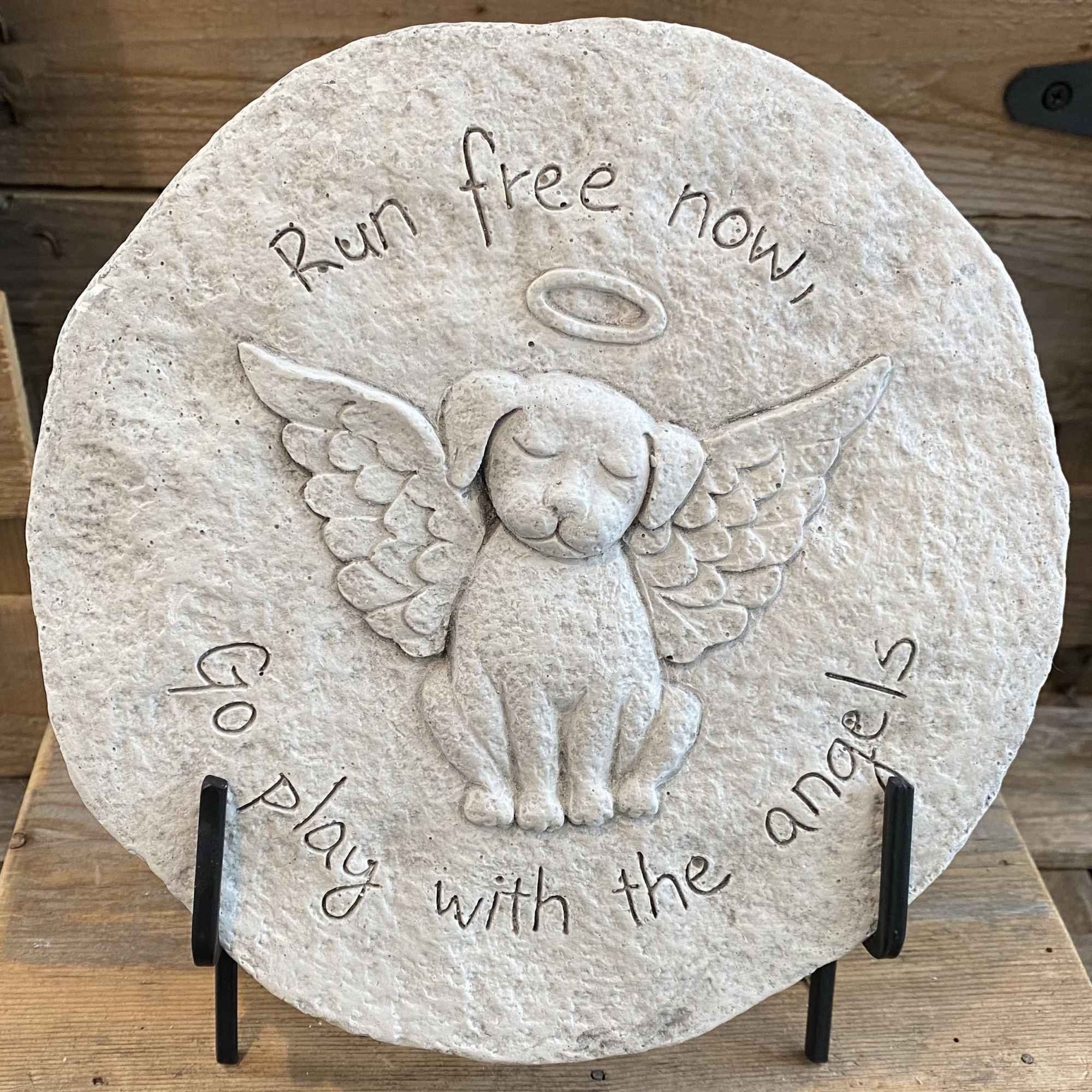 Round stone plaque with an angel dog relief and engraved text