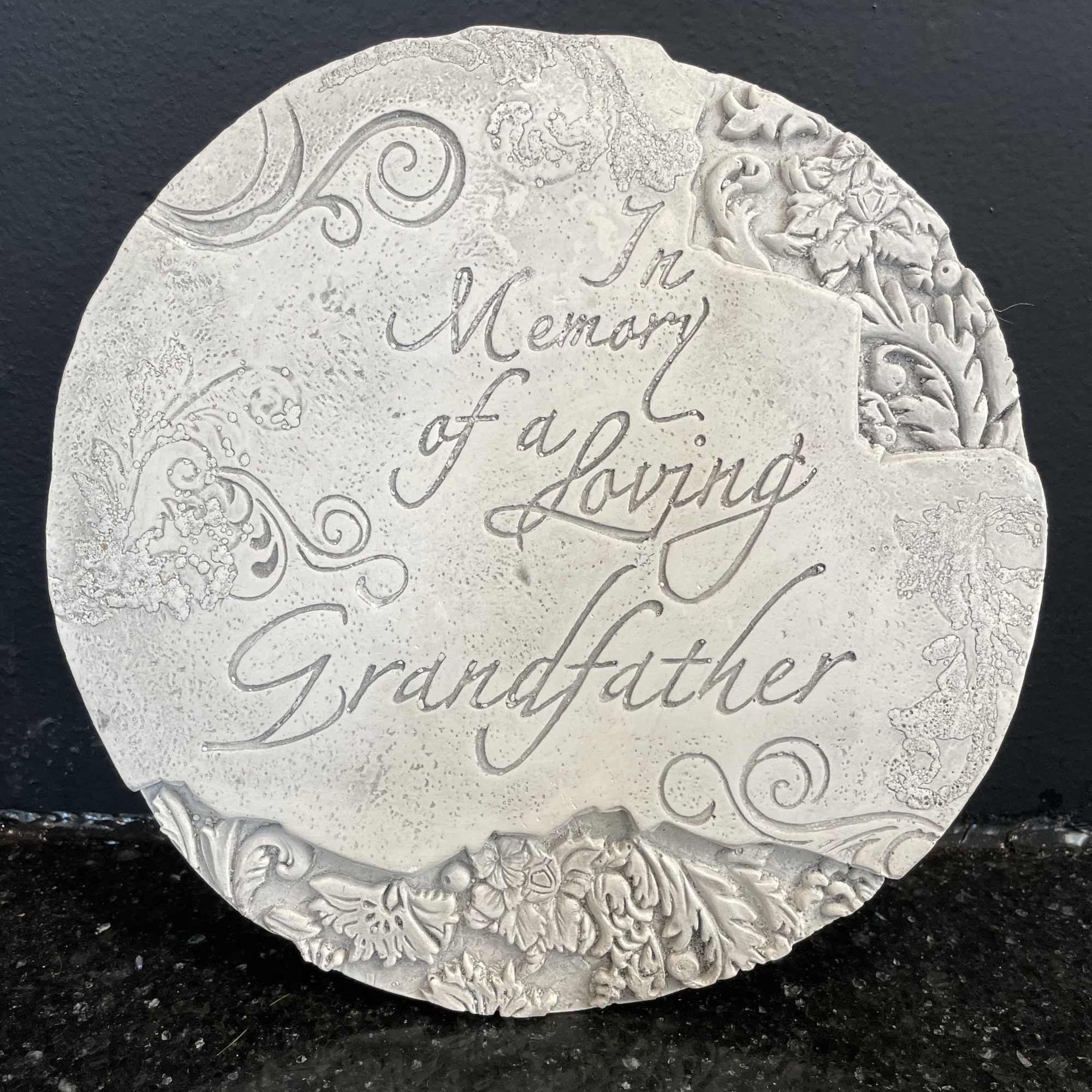 Round memorial plaque reading "In Memory of a Loving Grandfather"