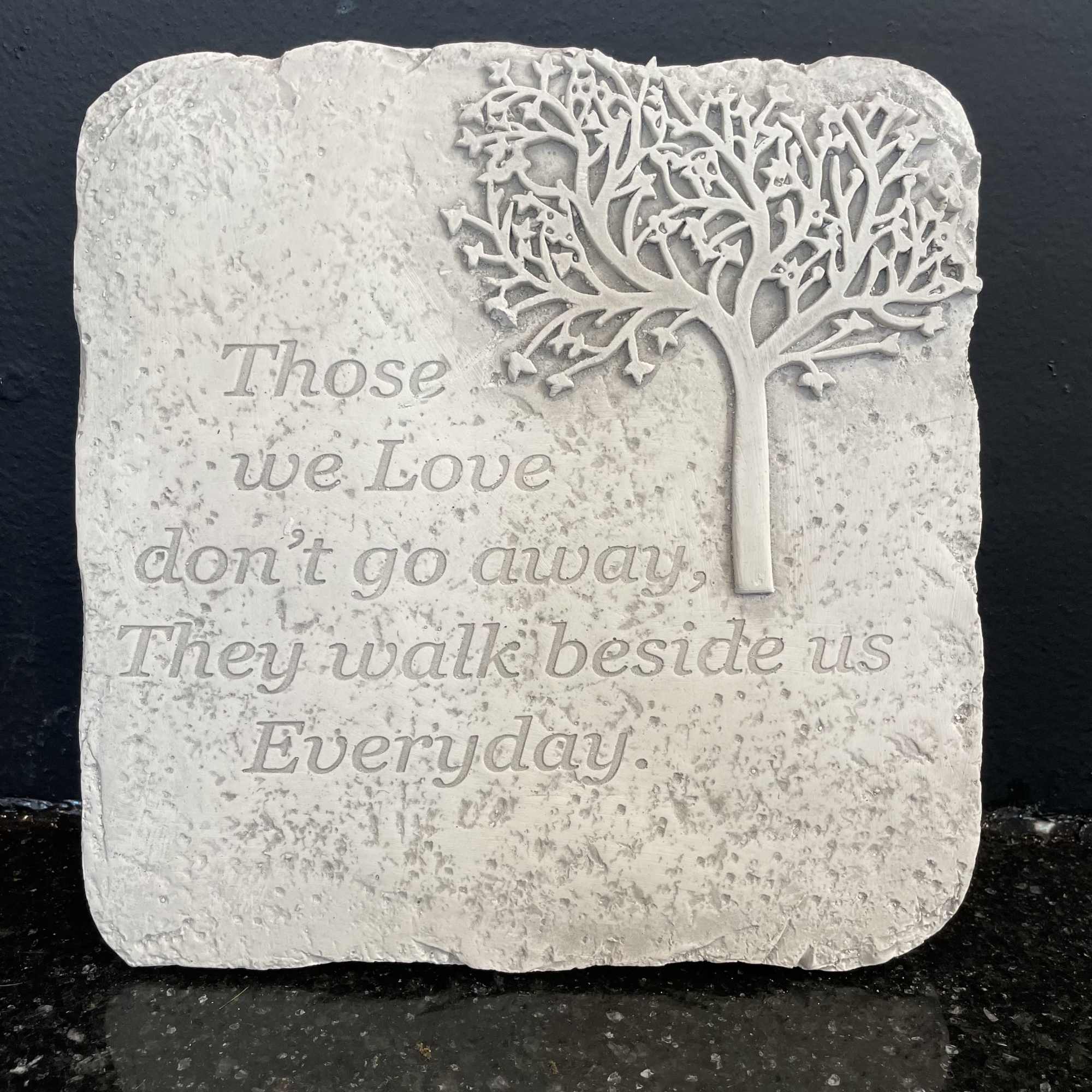 Stone memorial plaque with a tree relief and engraved quote
