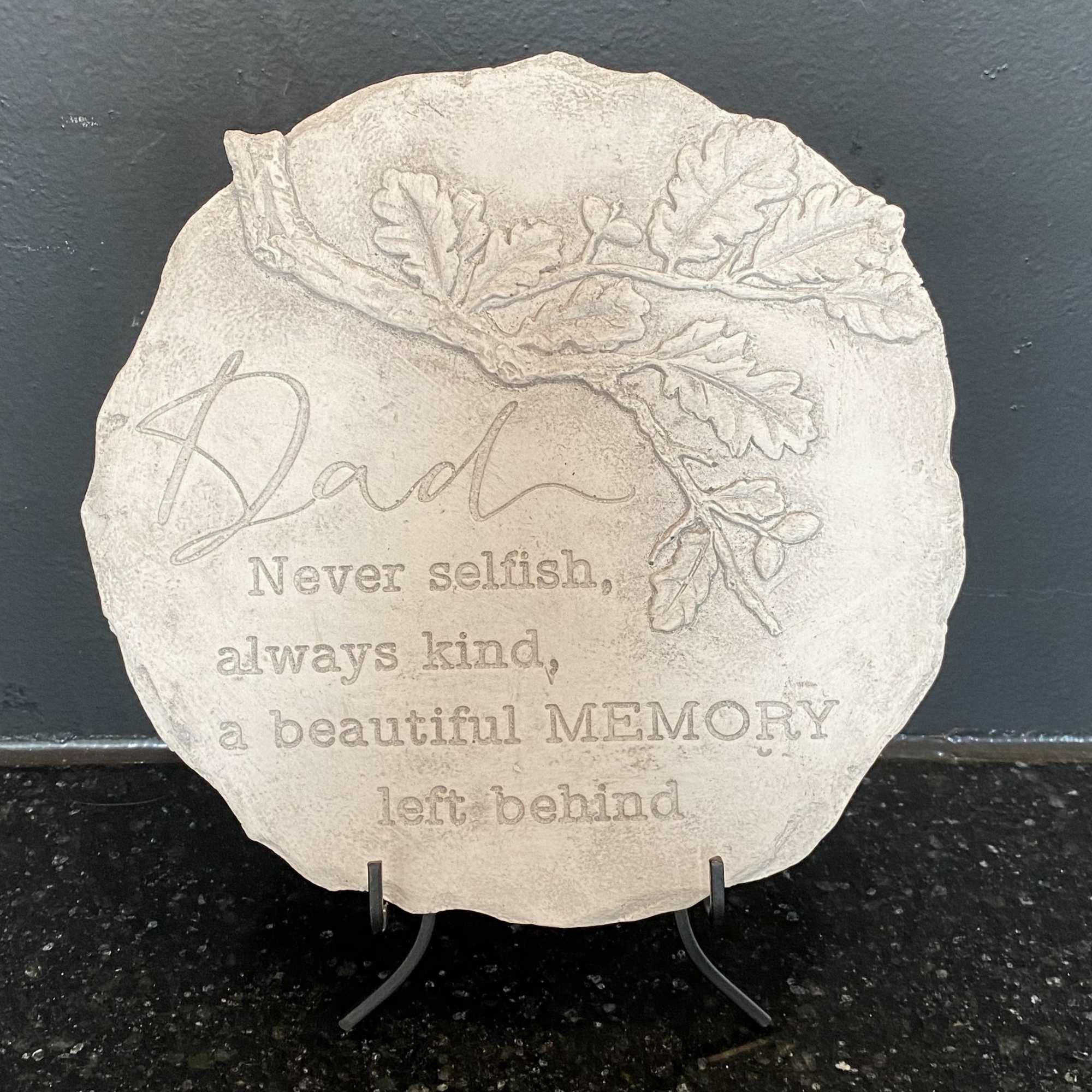 Round memorial plaque with an oak leaf design and engraved tribute text