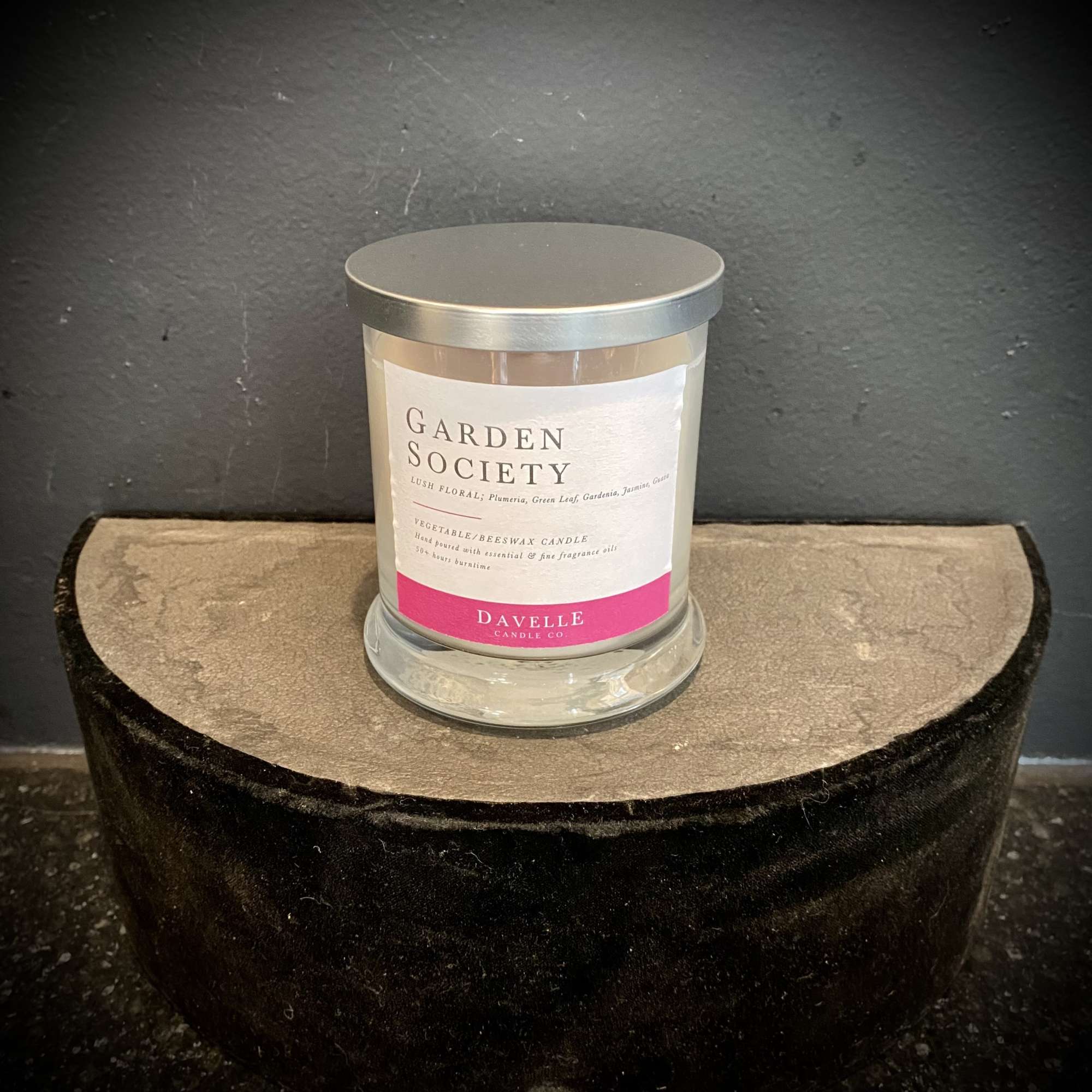 Glass candle jar with silver lid and floral label