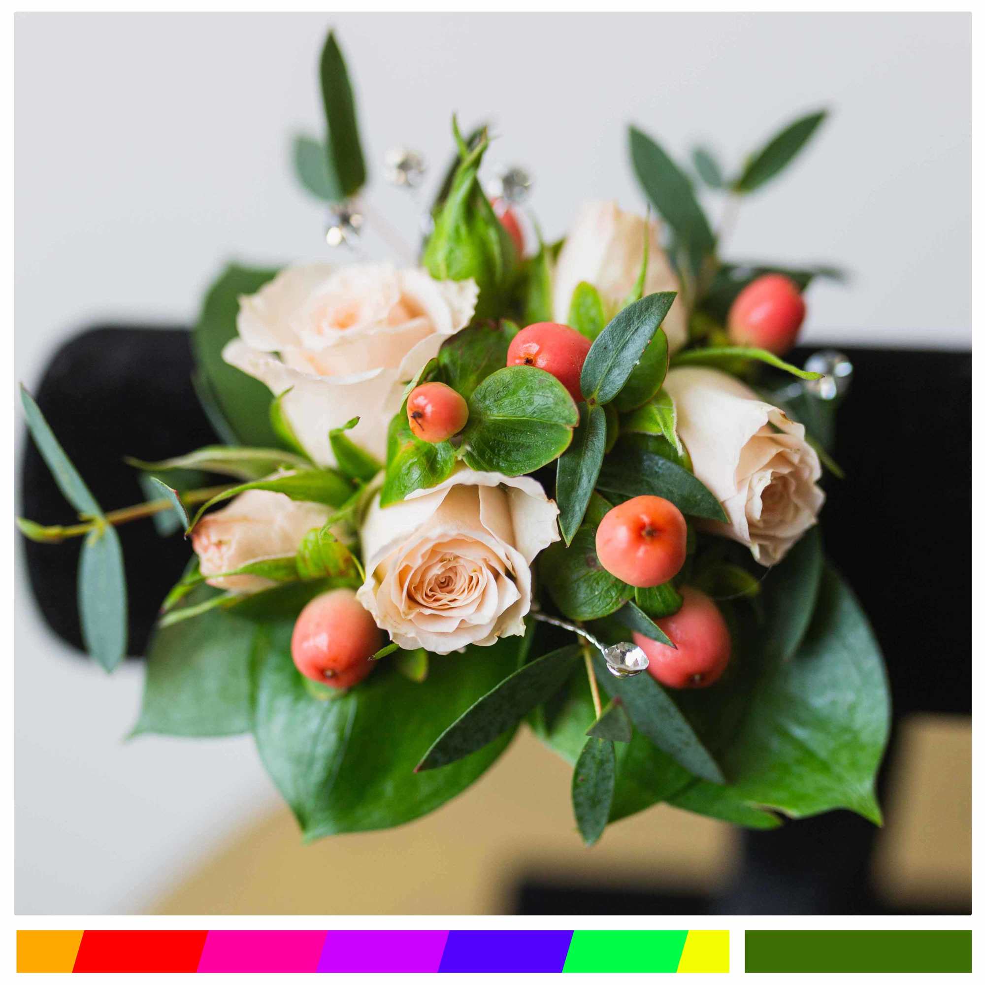 Bouquet of pale peach roses with red berries and greenery