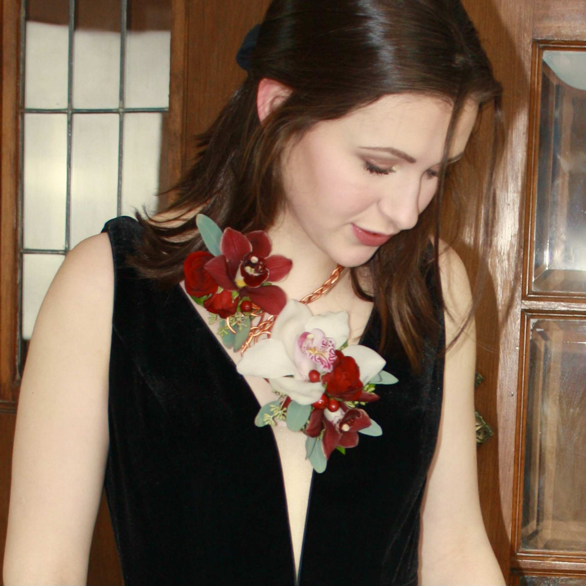 Woman wearing a red and white floral corsage on a black dress