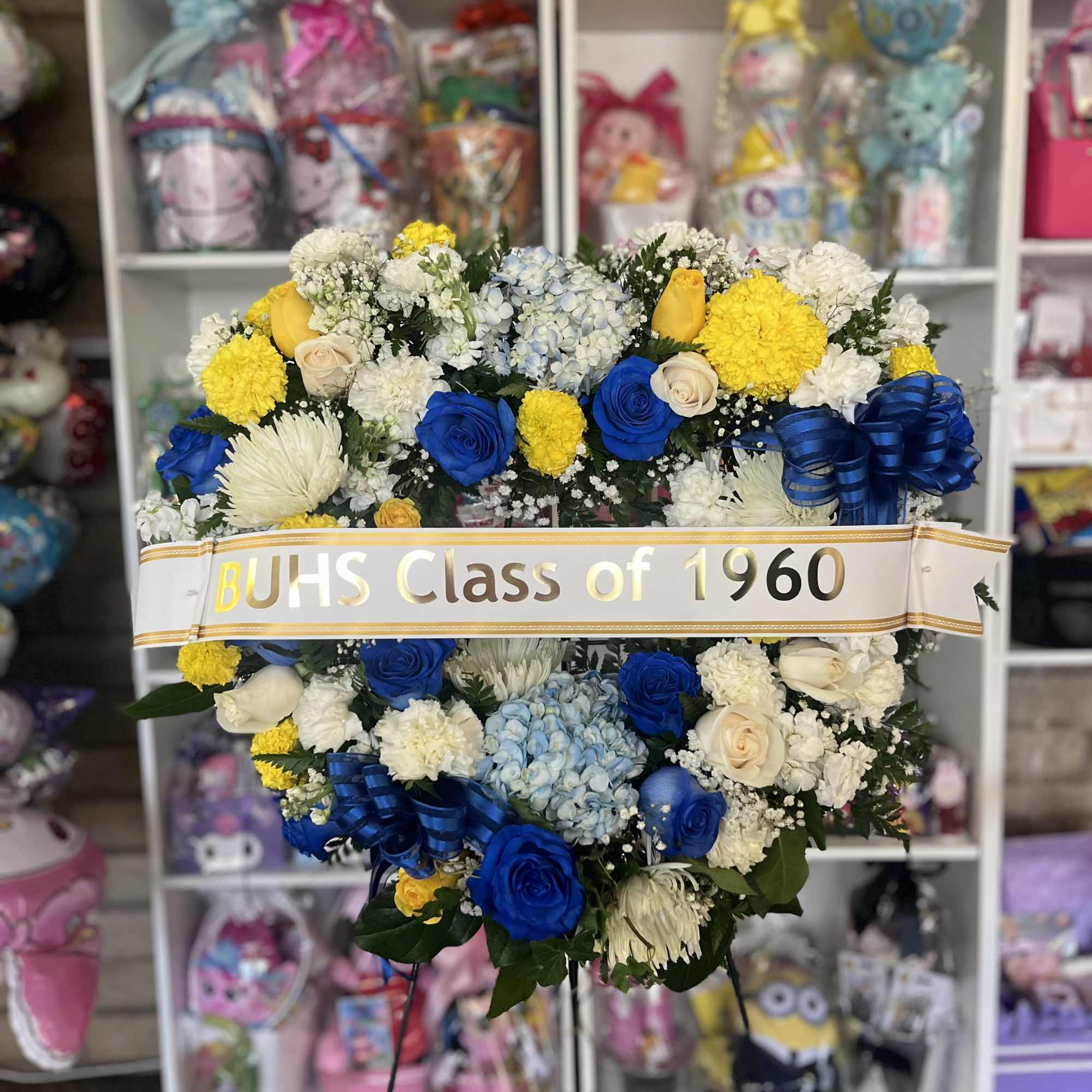 Large blue, white, and yellow floral wreath with a class ribbon