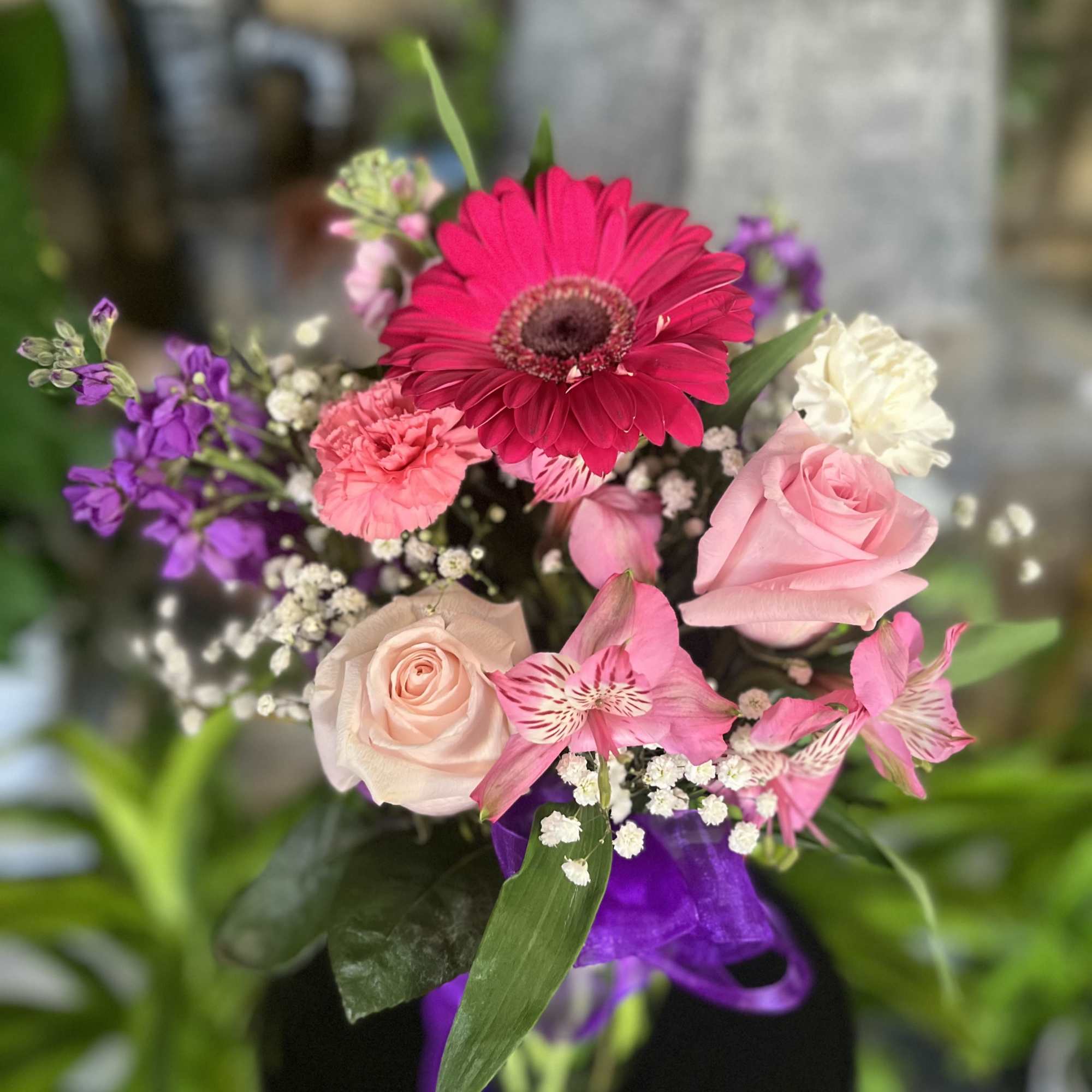 Mixed bouquet with pink gerbera, roses, carnations, and purple flowers