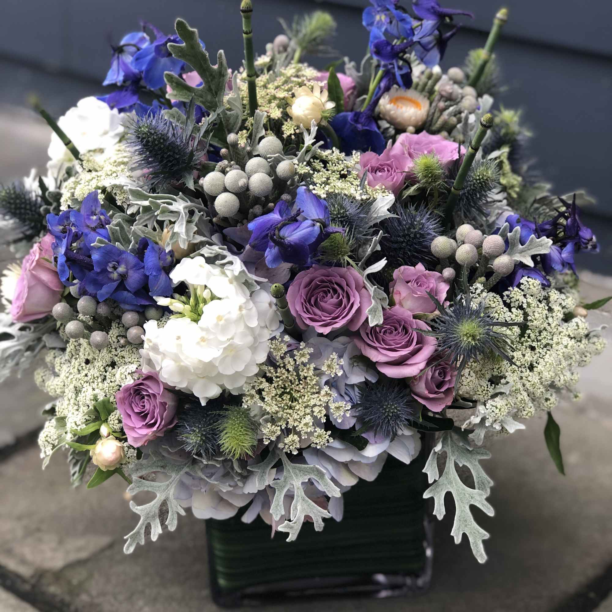Mixed bouquet of purple and white flowers in a black vase
