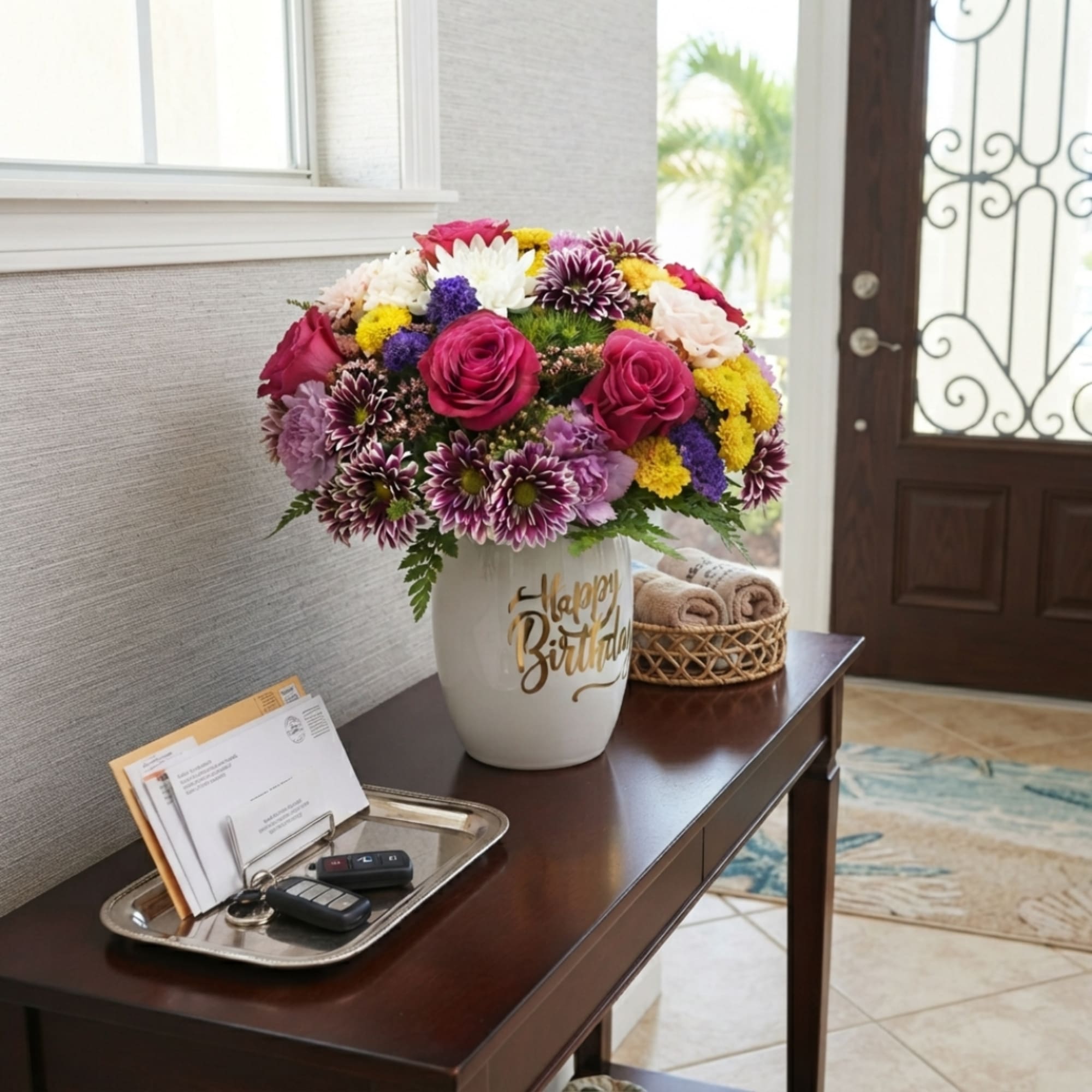 Colorful mixed flower arrangement in a white vase with gold "Happy Birthday" lettering