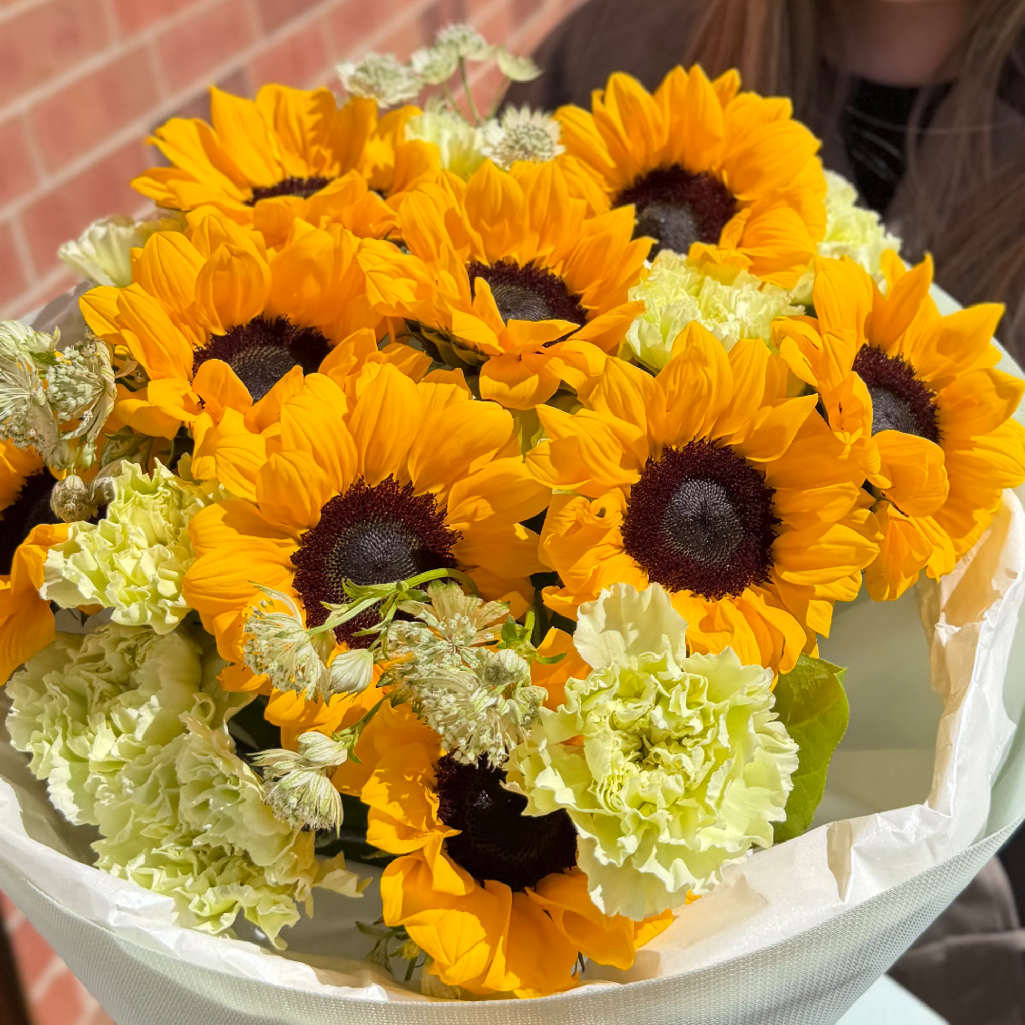 Bouquet of sunflowers and pale green carnations wrapped in white paper, photo 7 of 8