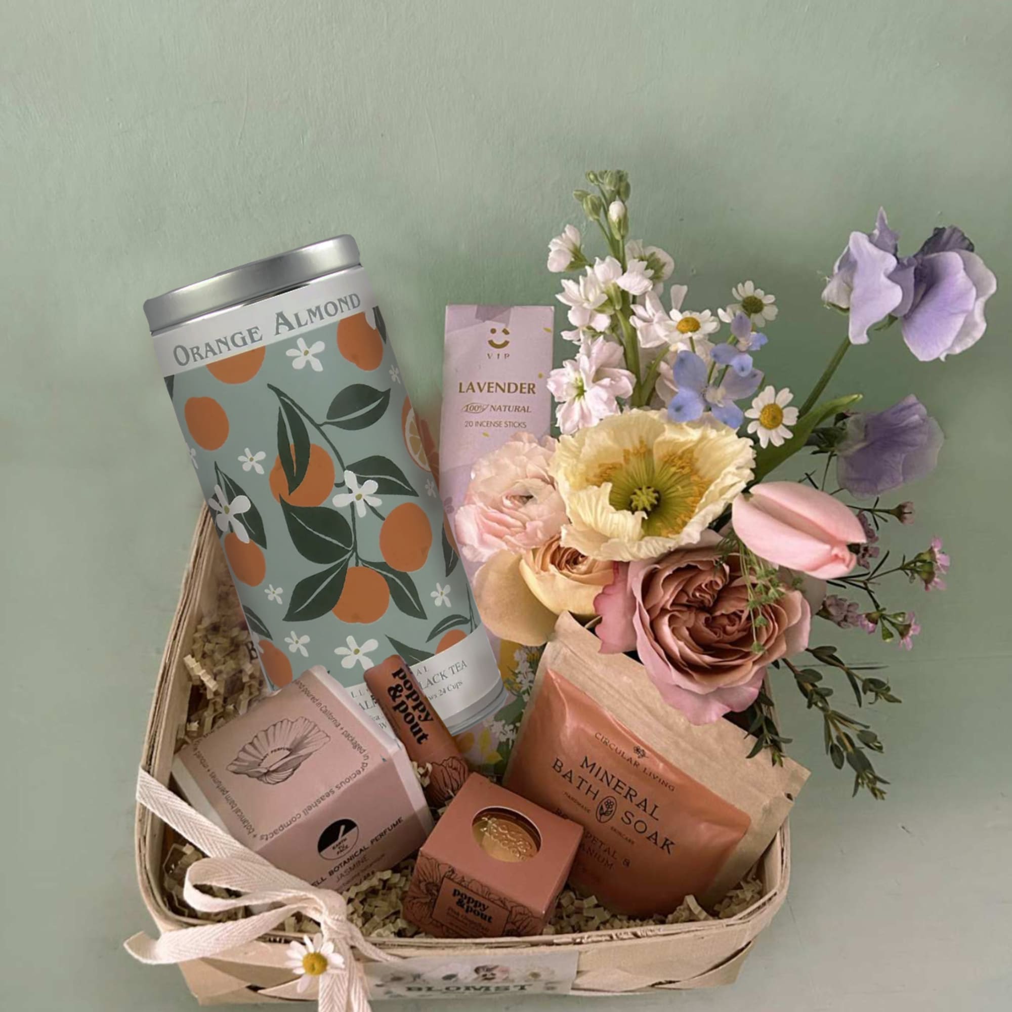 Gift basket with flowers, bath items, and a ribbon bow