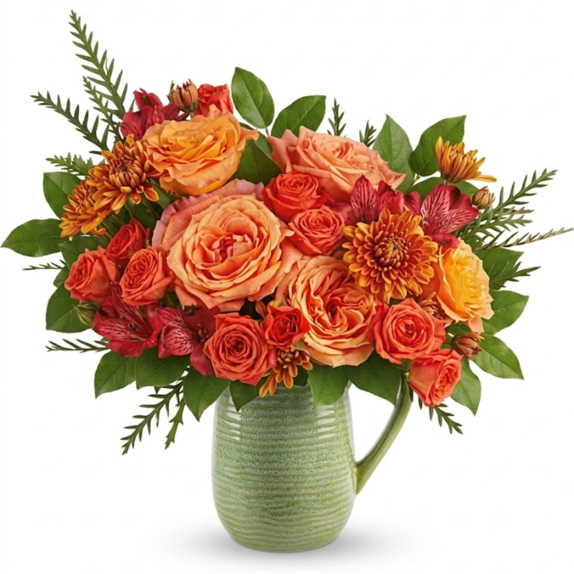 Orange and red flower arrangement in a green ceramic pitcher