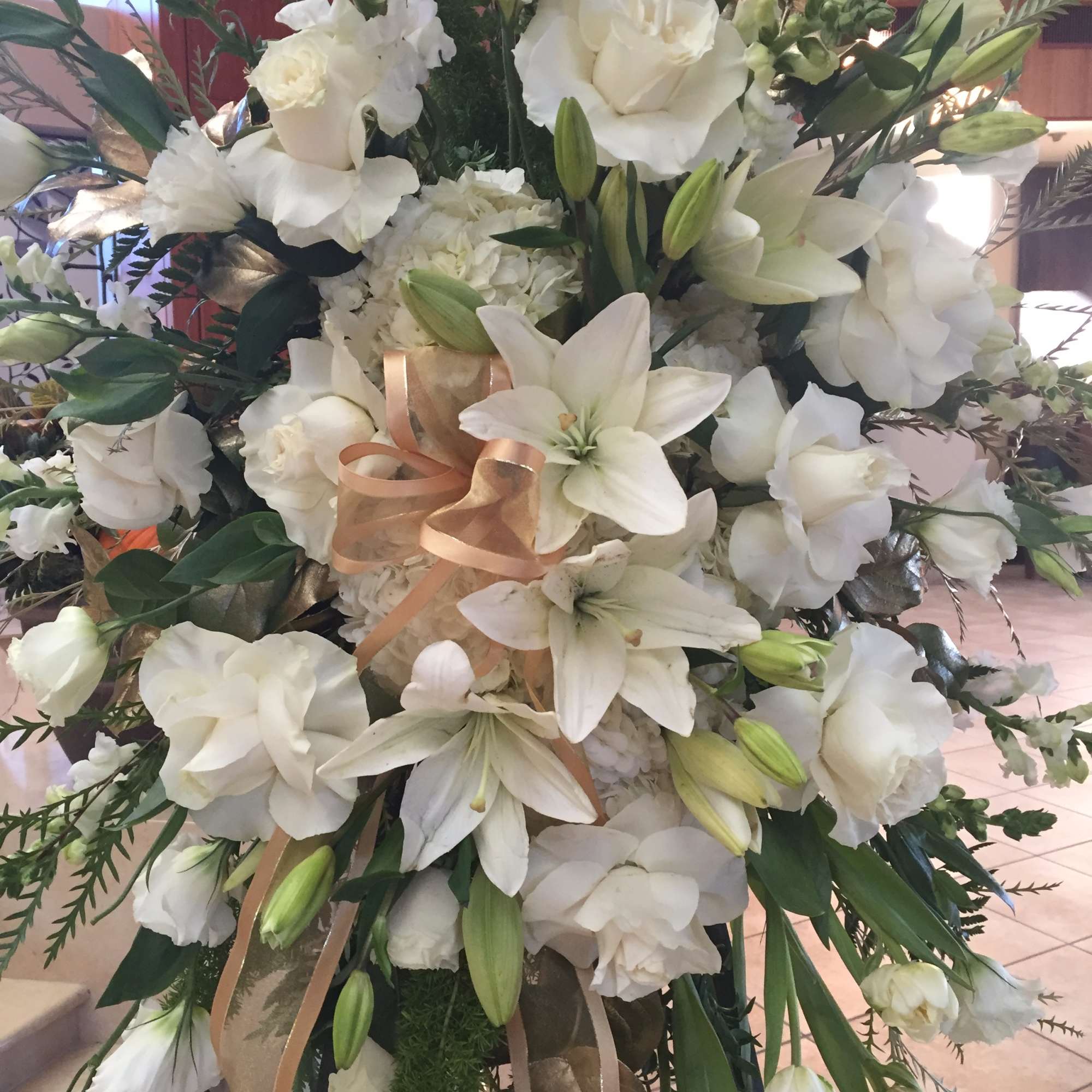 Large white floral standing arrangement with lilies and roses