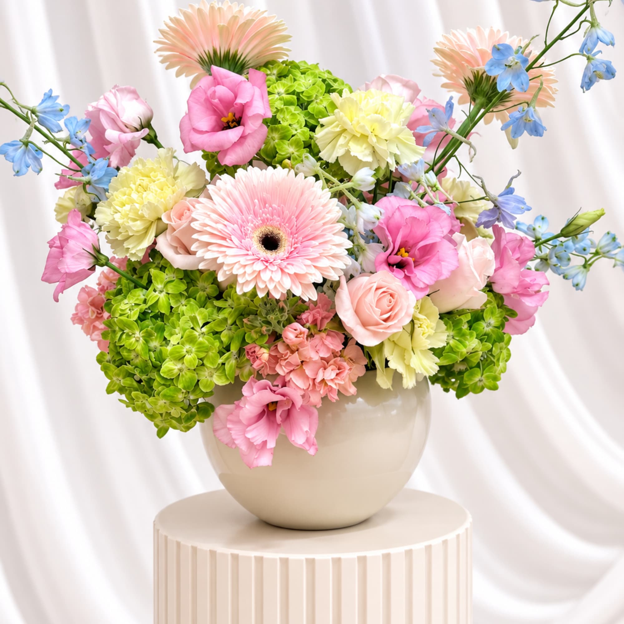 Pastel mixed flower arrangement in a beige vase