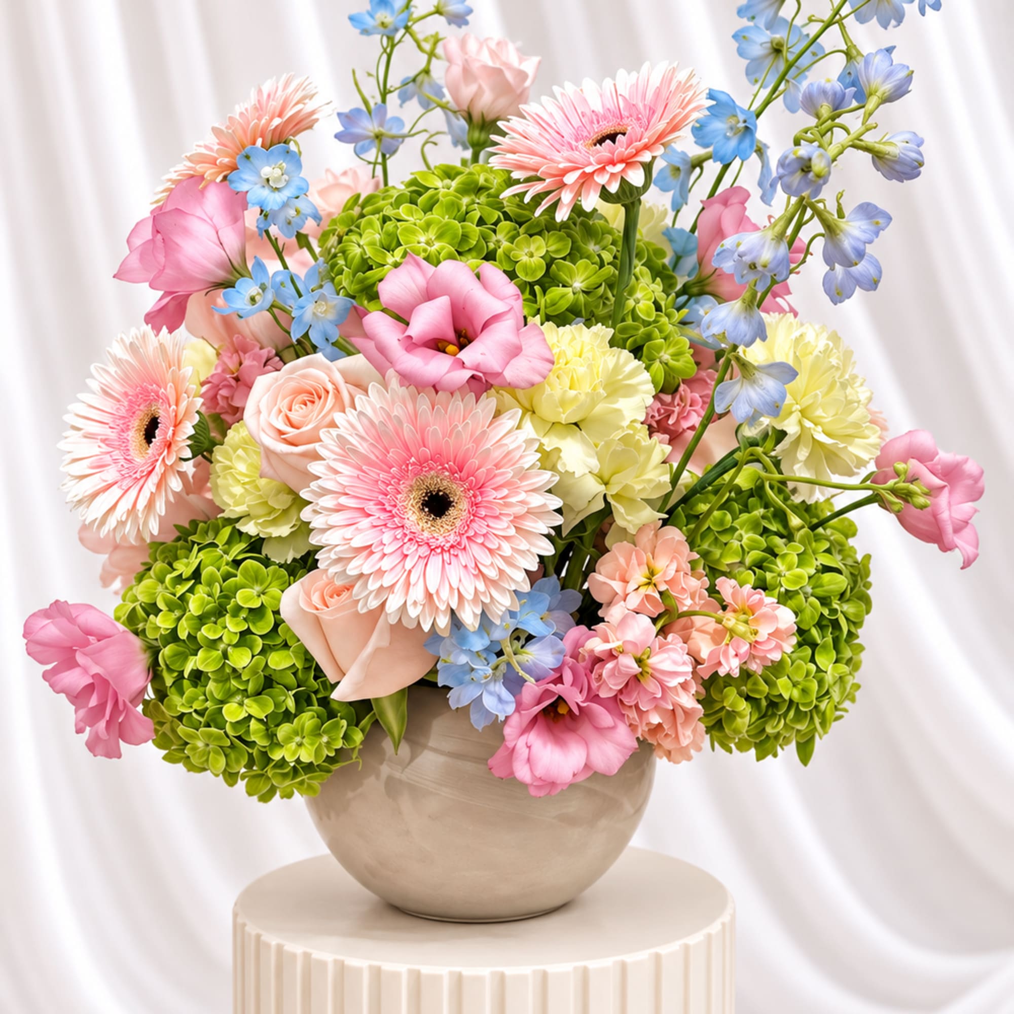 Pink and blue mixed flowers arranged in a beige vase