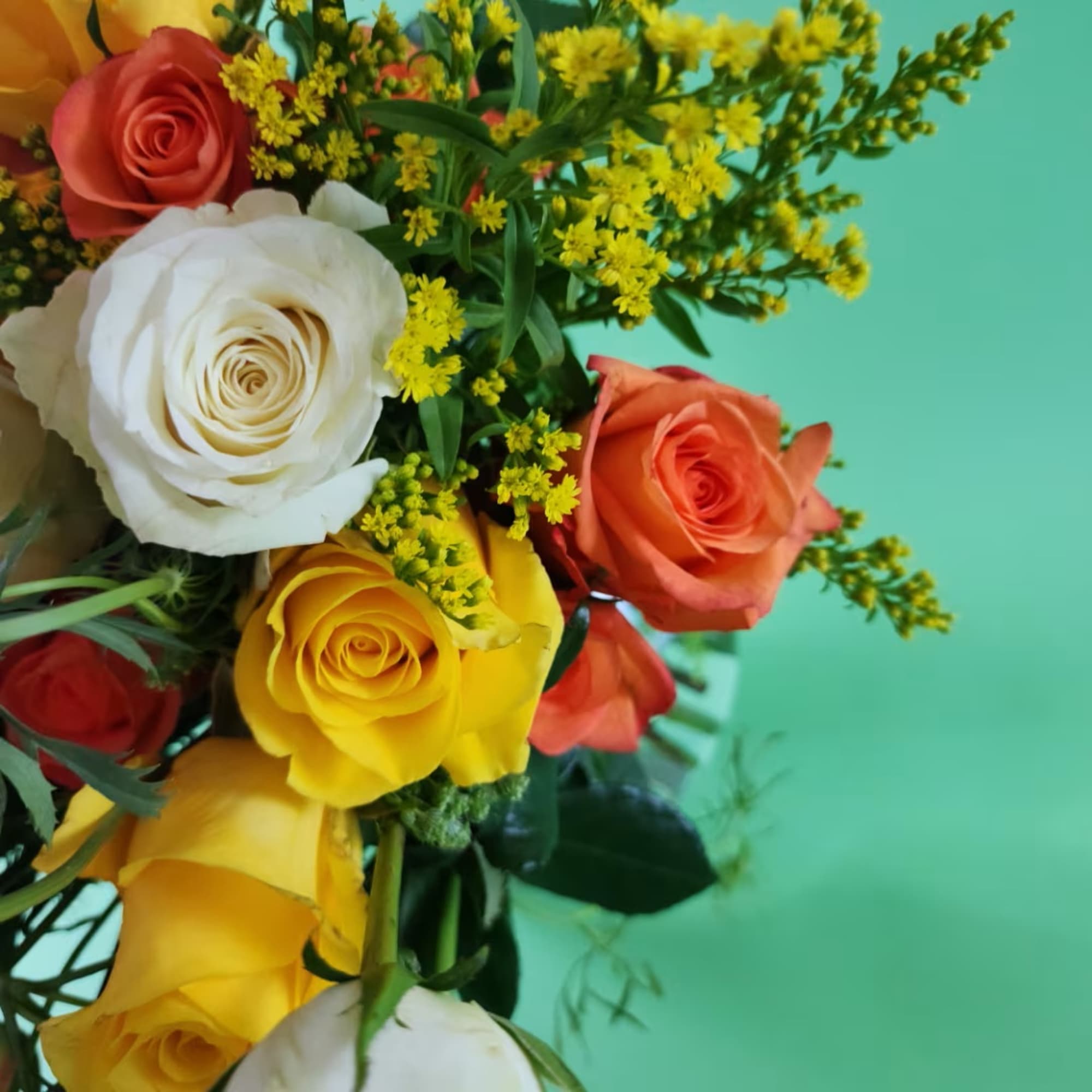 Bouquet of multicolored roses with yellow filler flowers