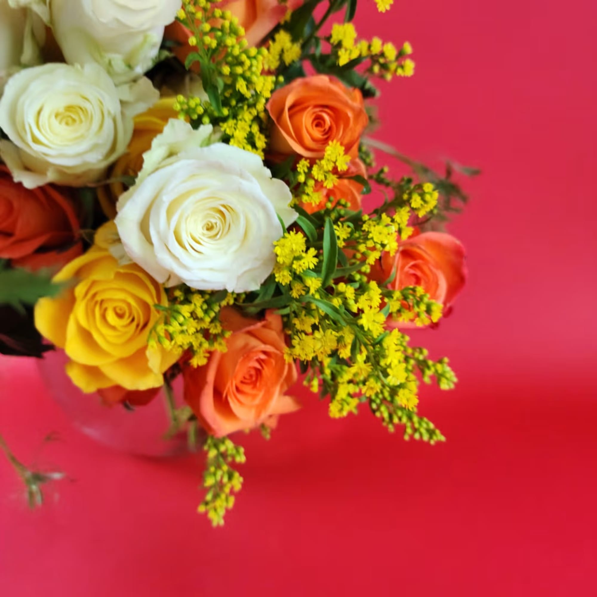 Bouquet of white, yellow, and orange roses with small yellow filler flowers