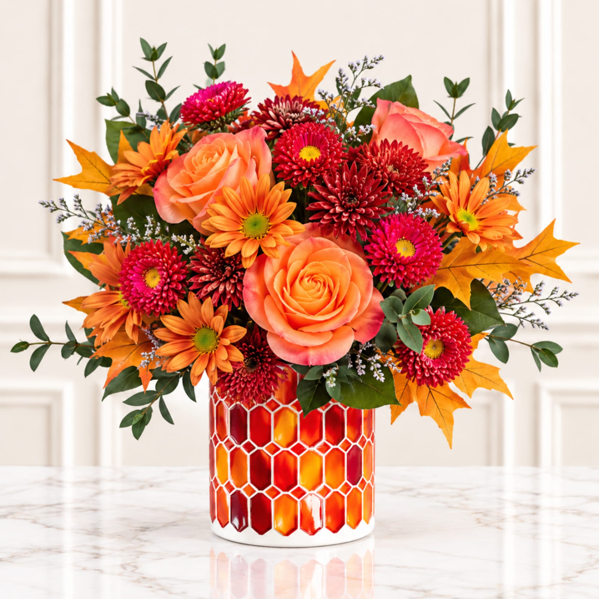 Orange and red floral arrangement in a patterned vase