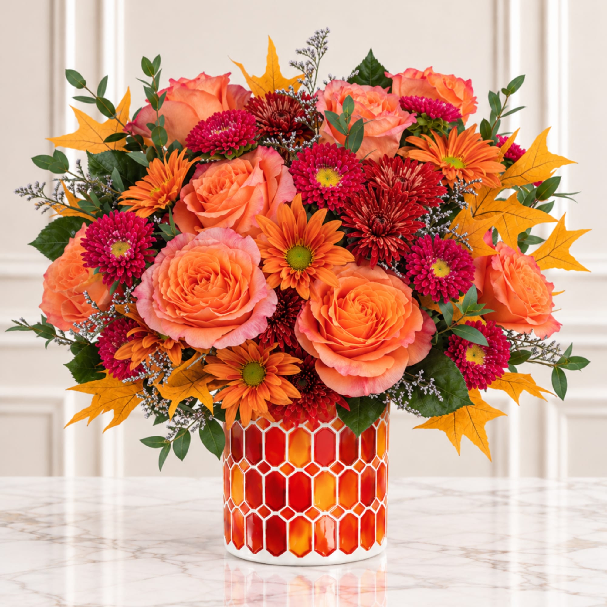 Orange and pink flower arrangement in a patterned vase