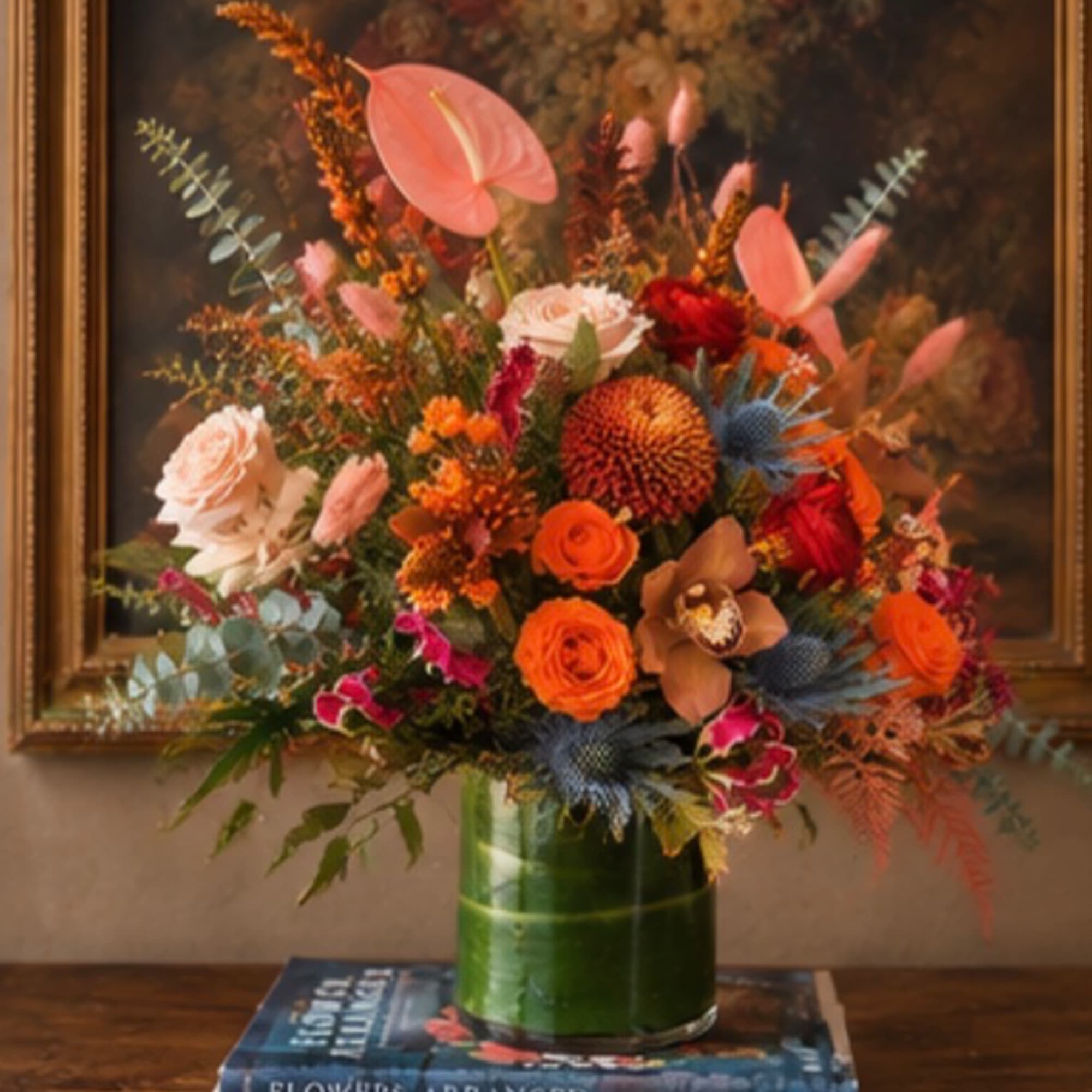 Mixed bouquet of orange, pink, and blue flowers in a green glass vase