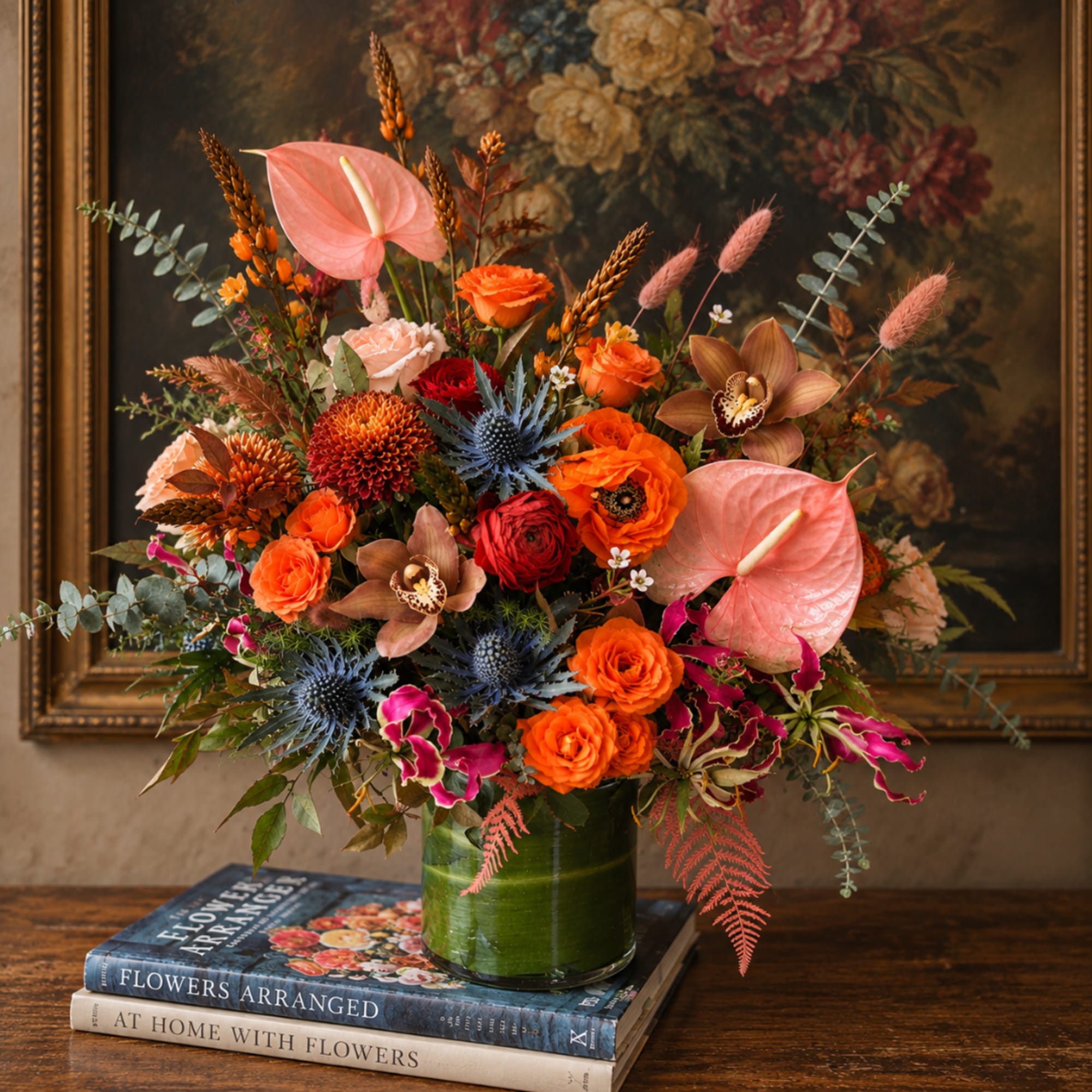 Bright mixed bouquet in a green glass vase with pink anthuriums and orange blooms