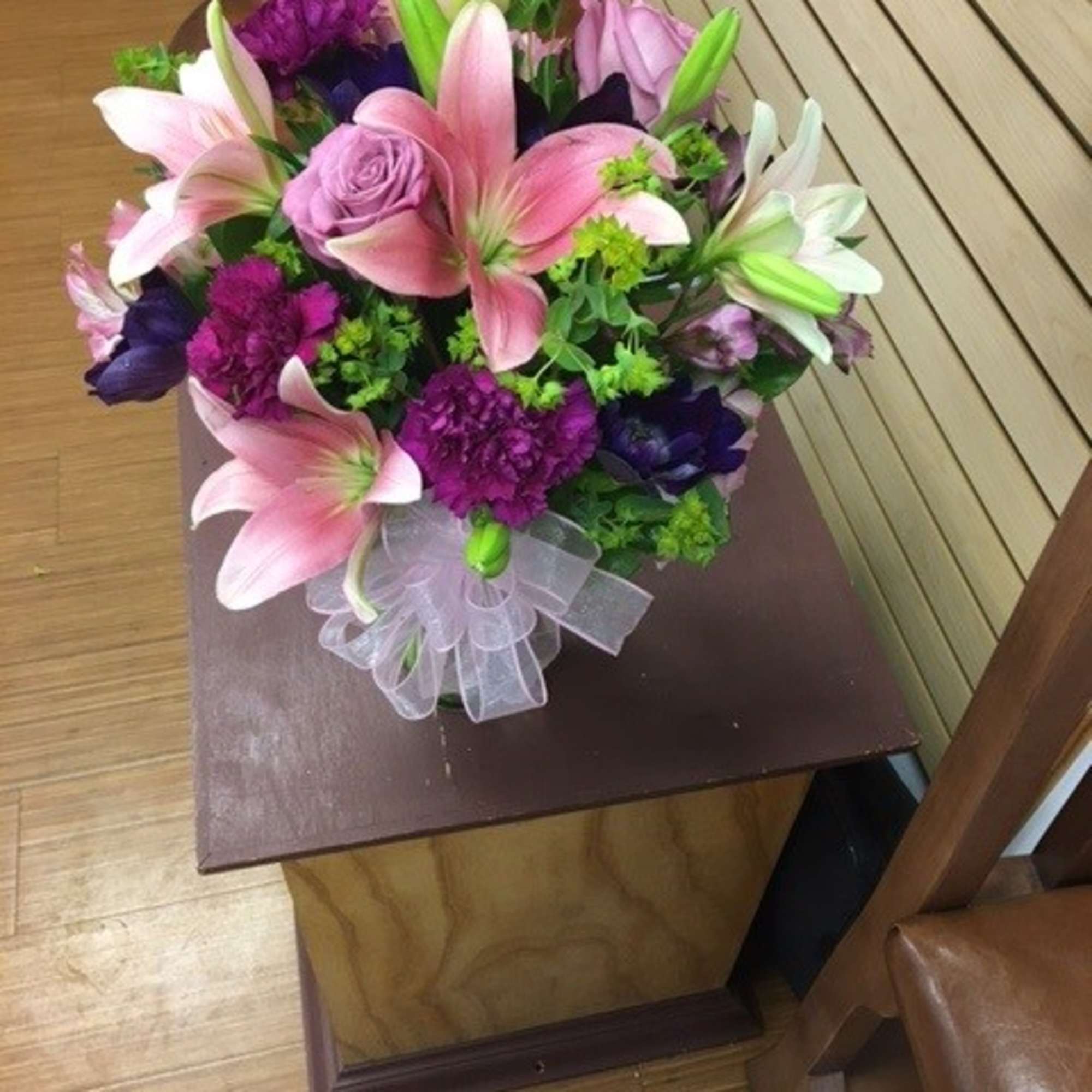 Bouquet of pink lilies and purple flowers tied with a sheer ribbon