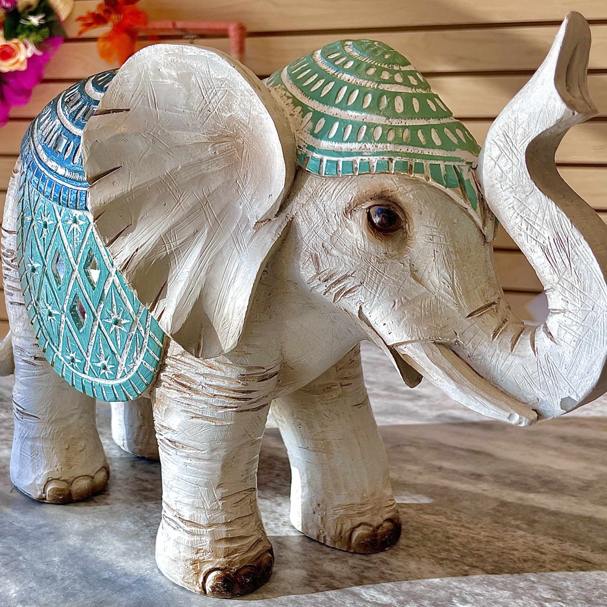 Carved white elephant figurine with blue and green painted accents