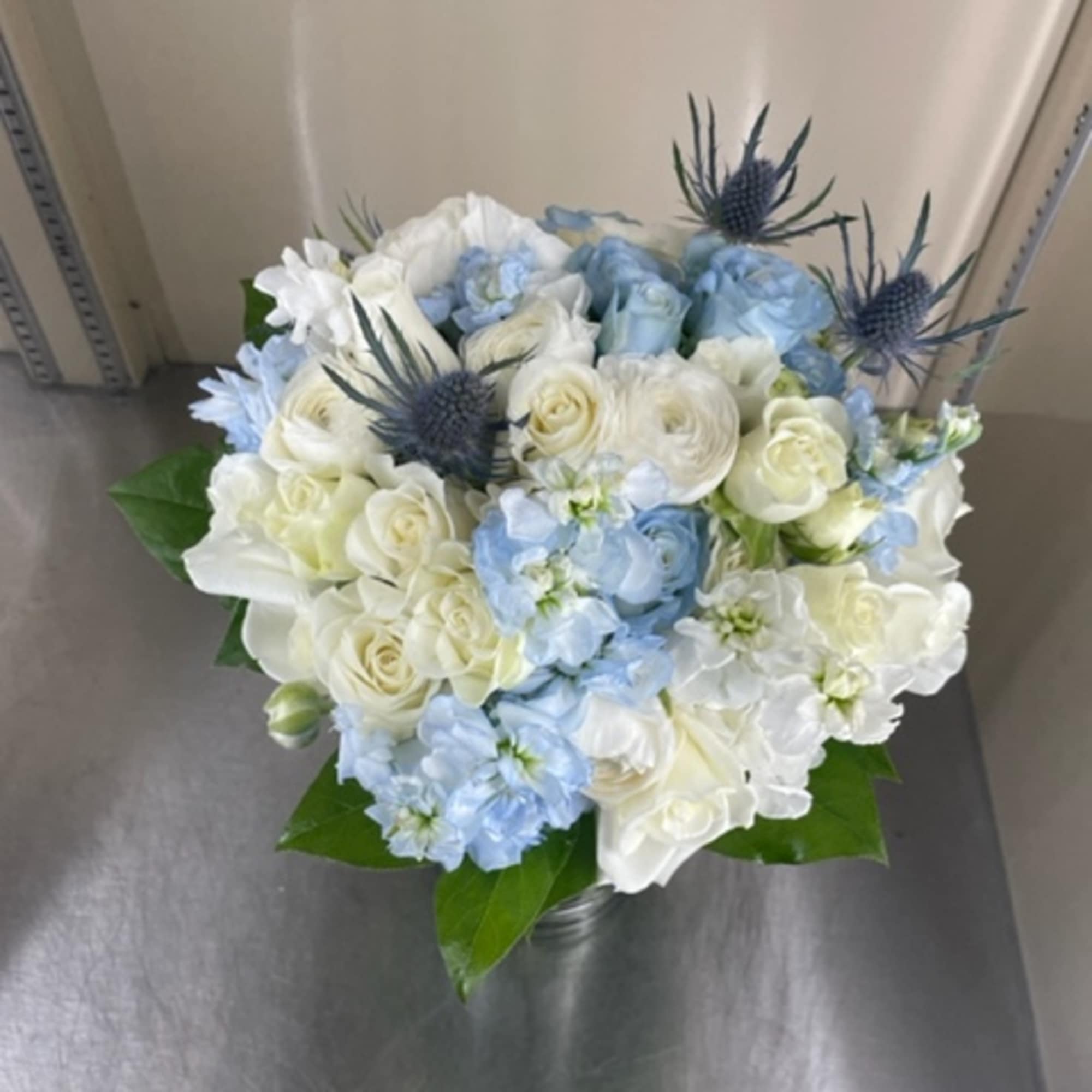 Bouquet of white and pale blue flowers with spiky blue thistles