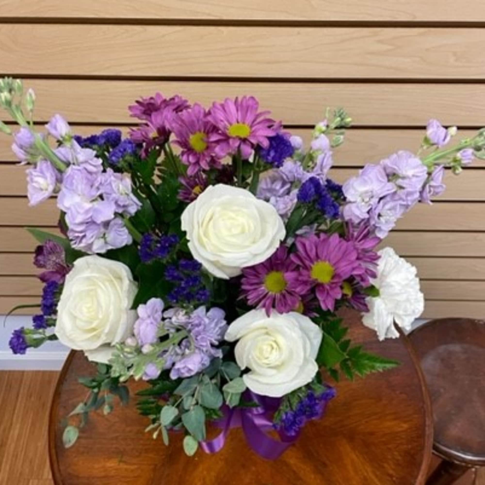 Bouquet of white roses and purple flowers with a ribbon