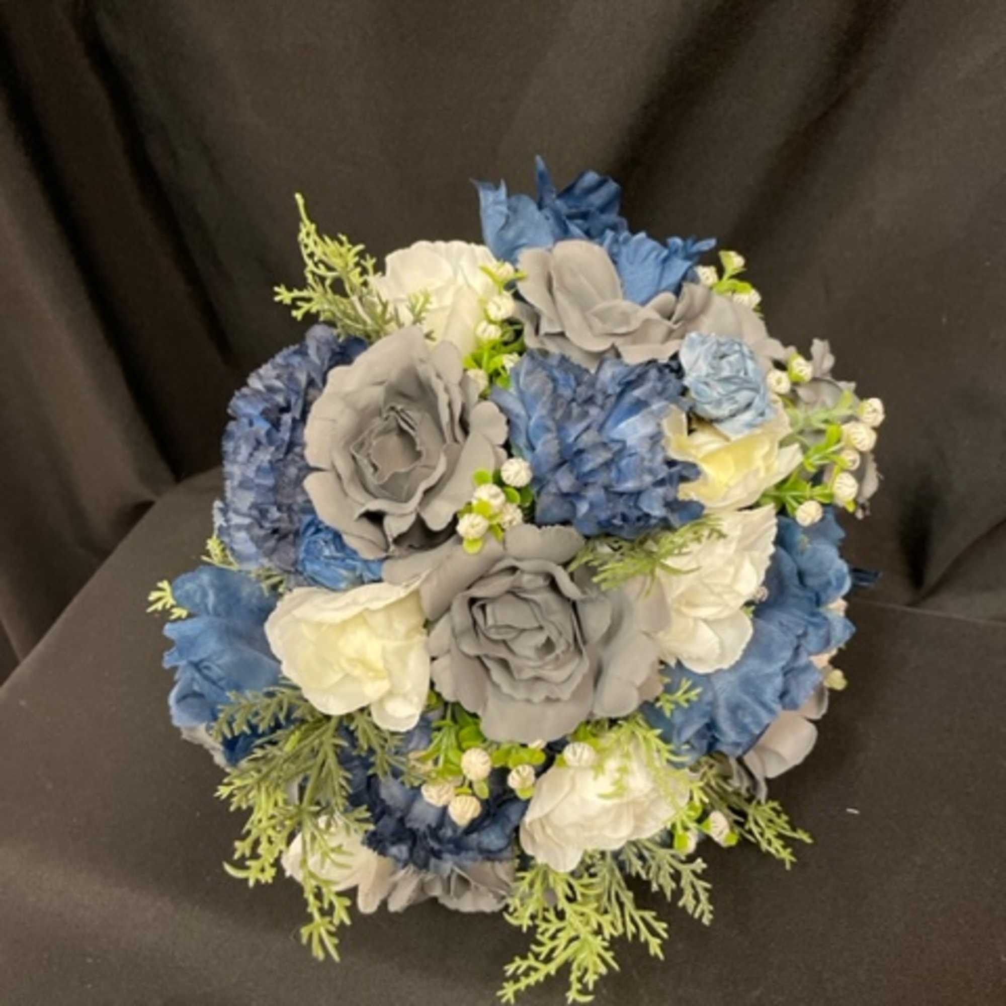 Bouquet of blue, gray, and white flowers with green filler