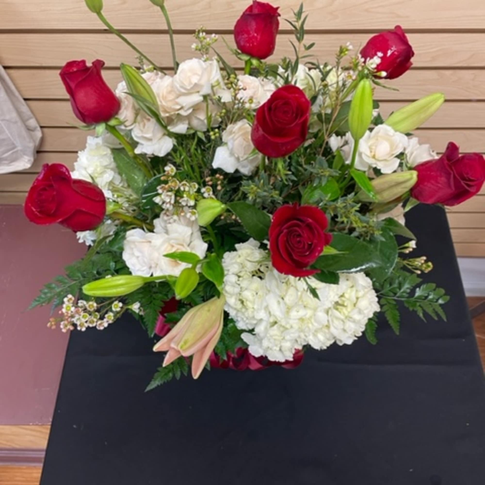 Red roses and white lilies arranged in a low bouquet