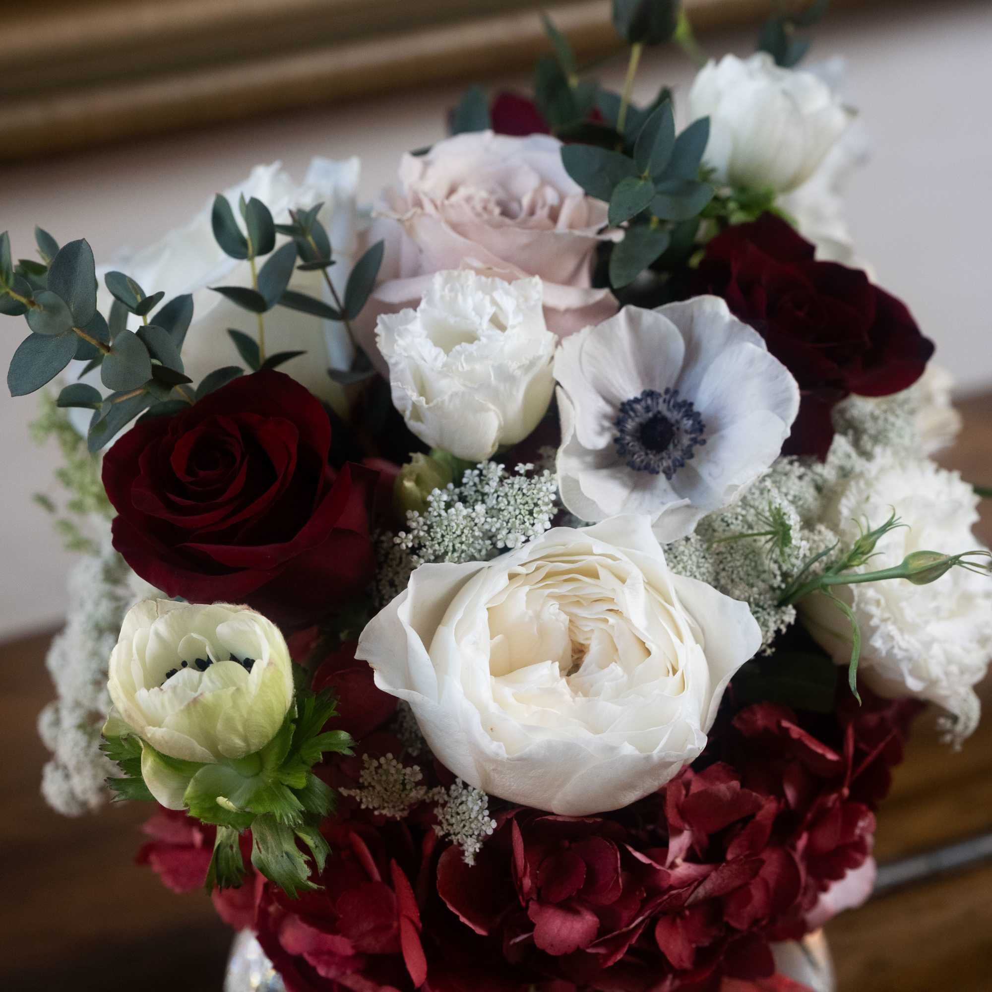 Bouquet of white, burgundy, and blush flowers in a glass vase