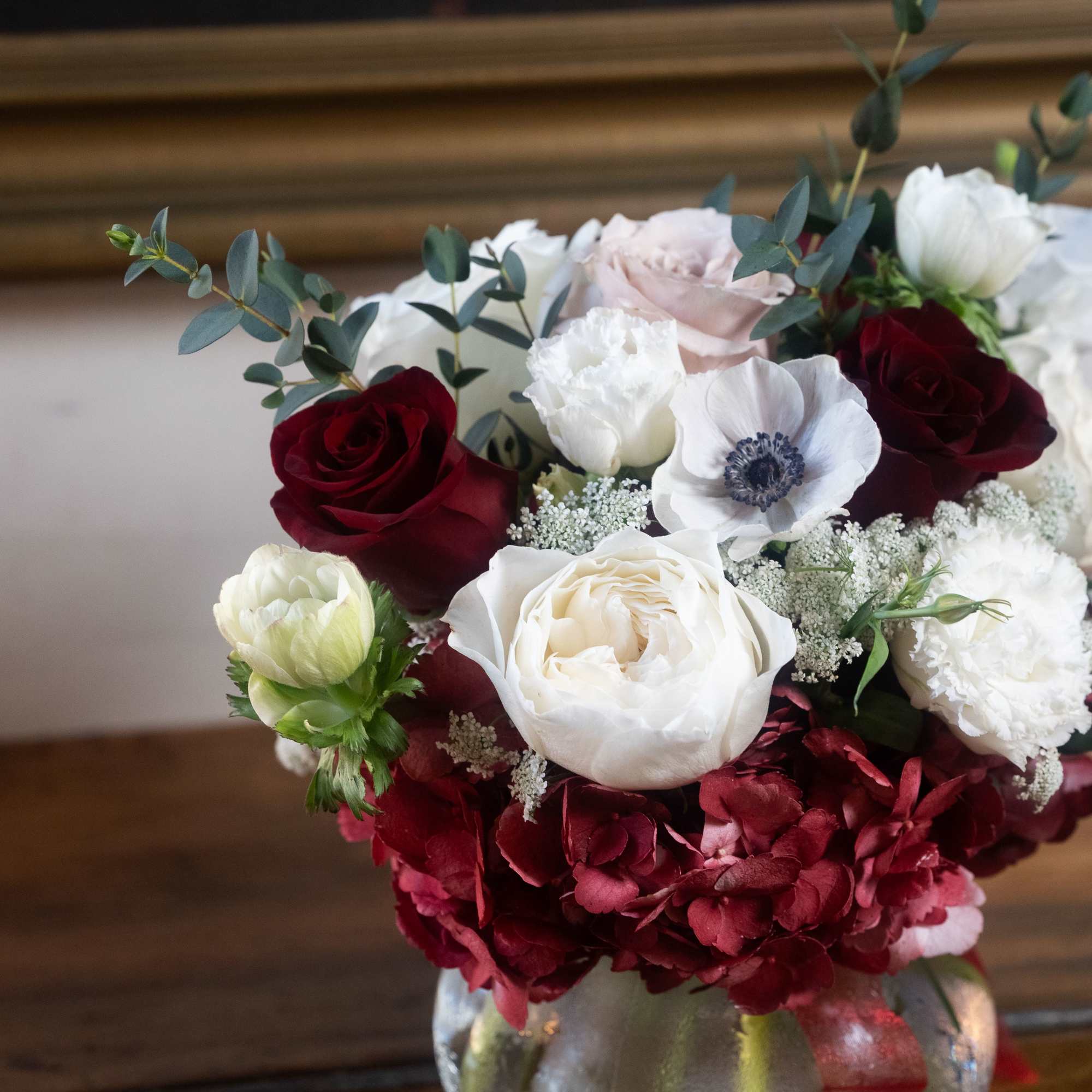 Bouquet of red, white, and blush flowers in a glass vase