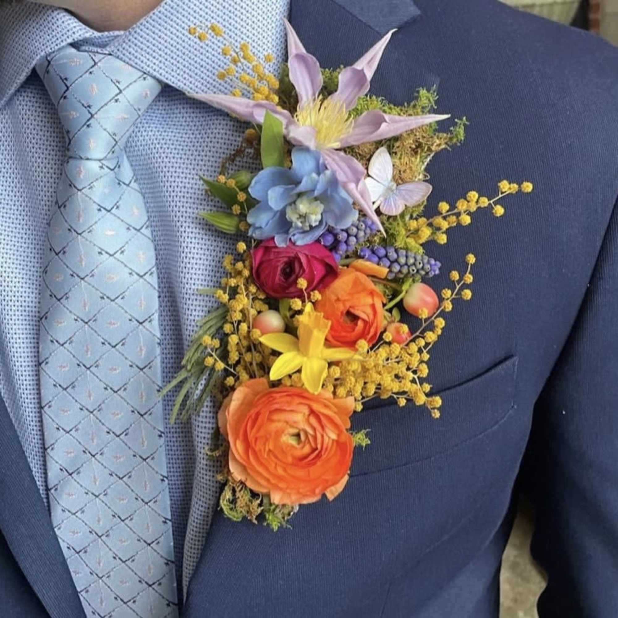 Colorful boutonniere pinned to a blue suit jacket