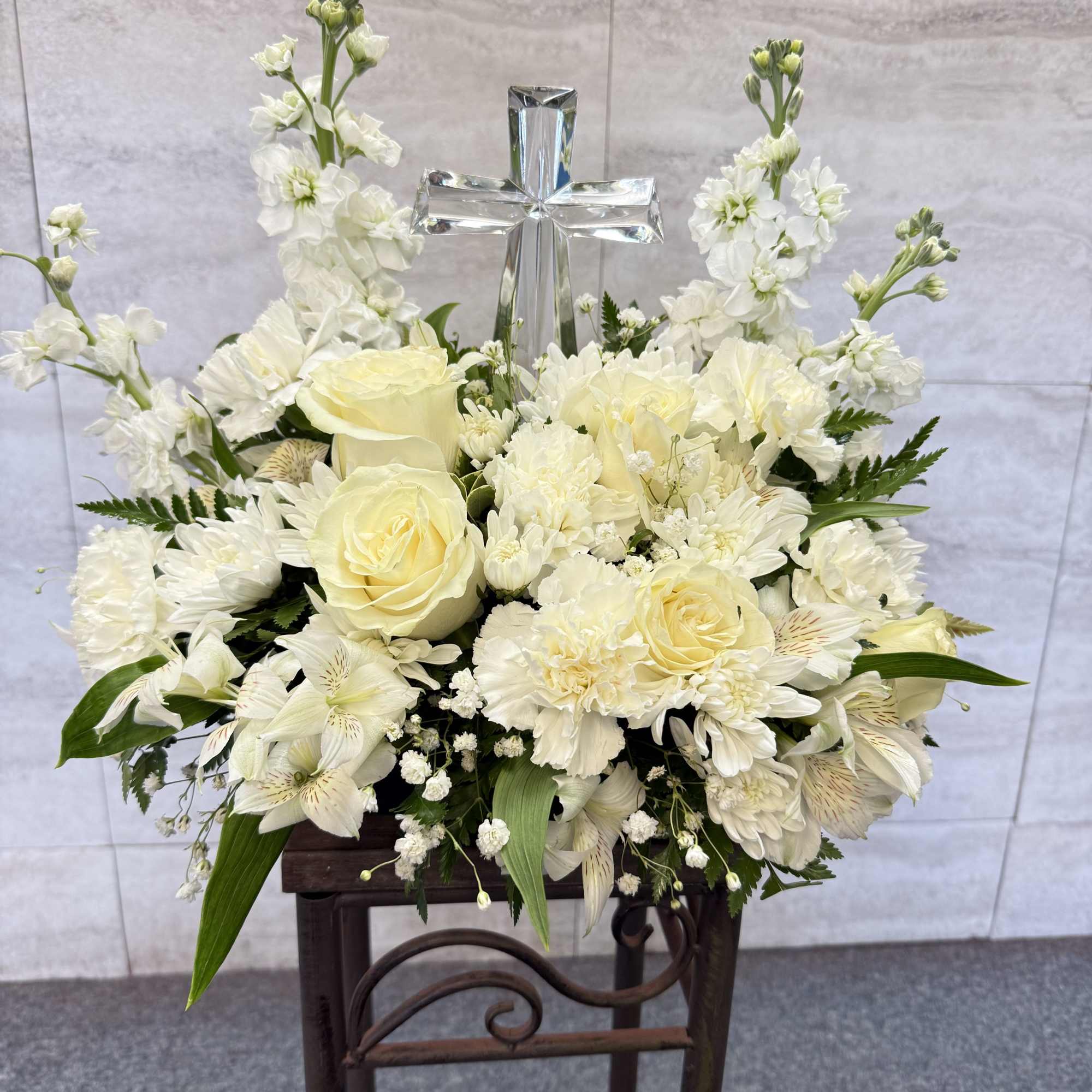 White floral arrangement with a silver cross centerpiece