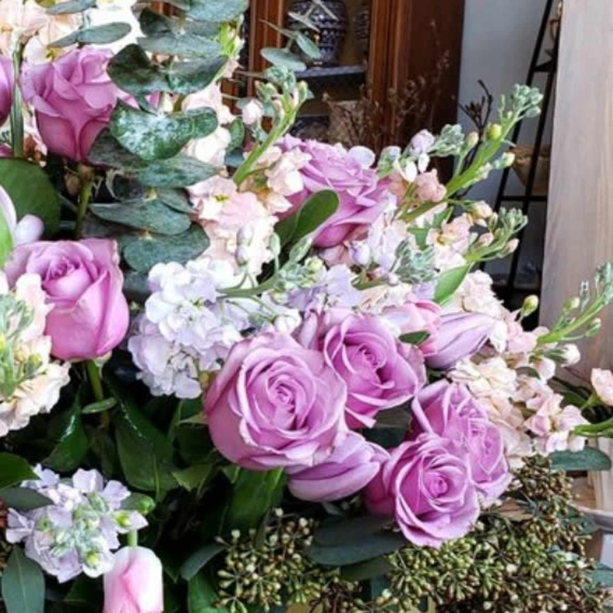 Lavender roses with pale filler flowers and eucalyptus in a bouquet