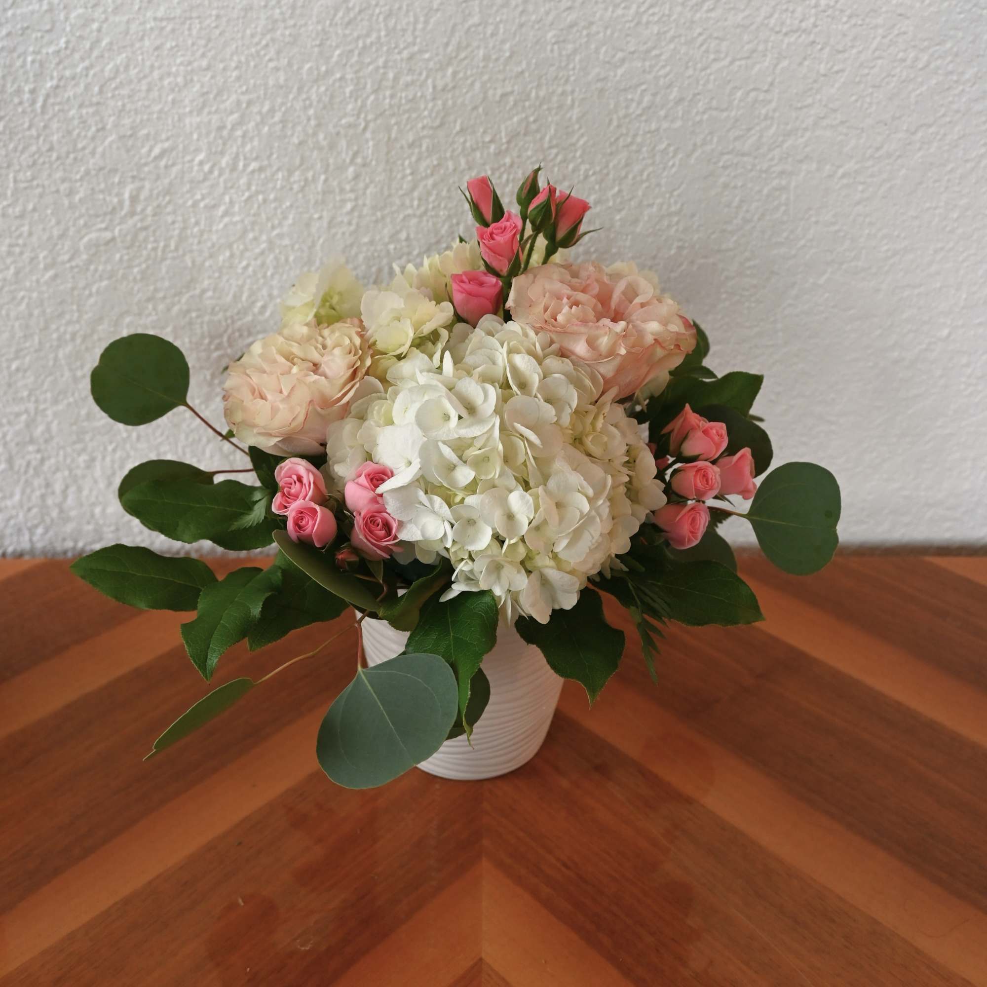 This comforting combination of pink roses and white hydrangea exudes warmth and