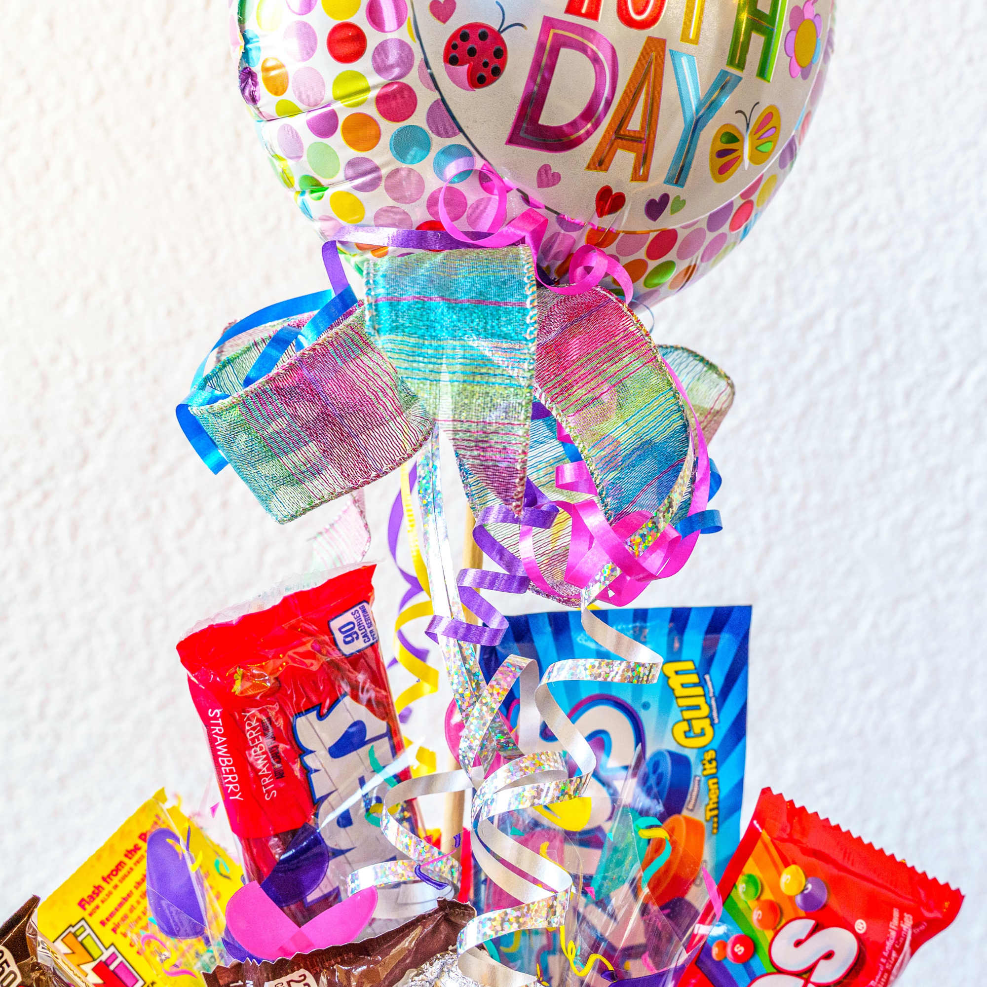 Birthday balloon bouquet with colorful candy bars and ribbons